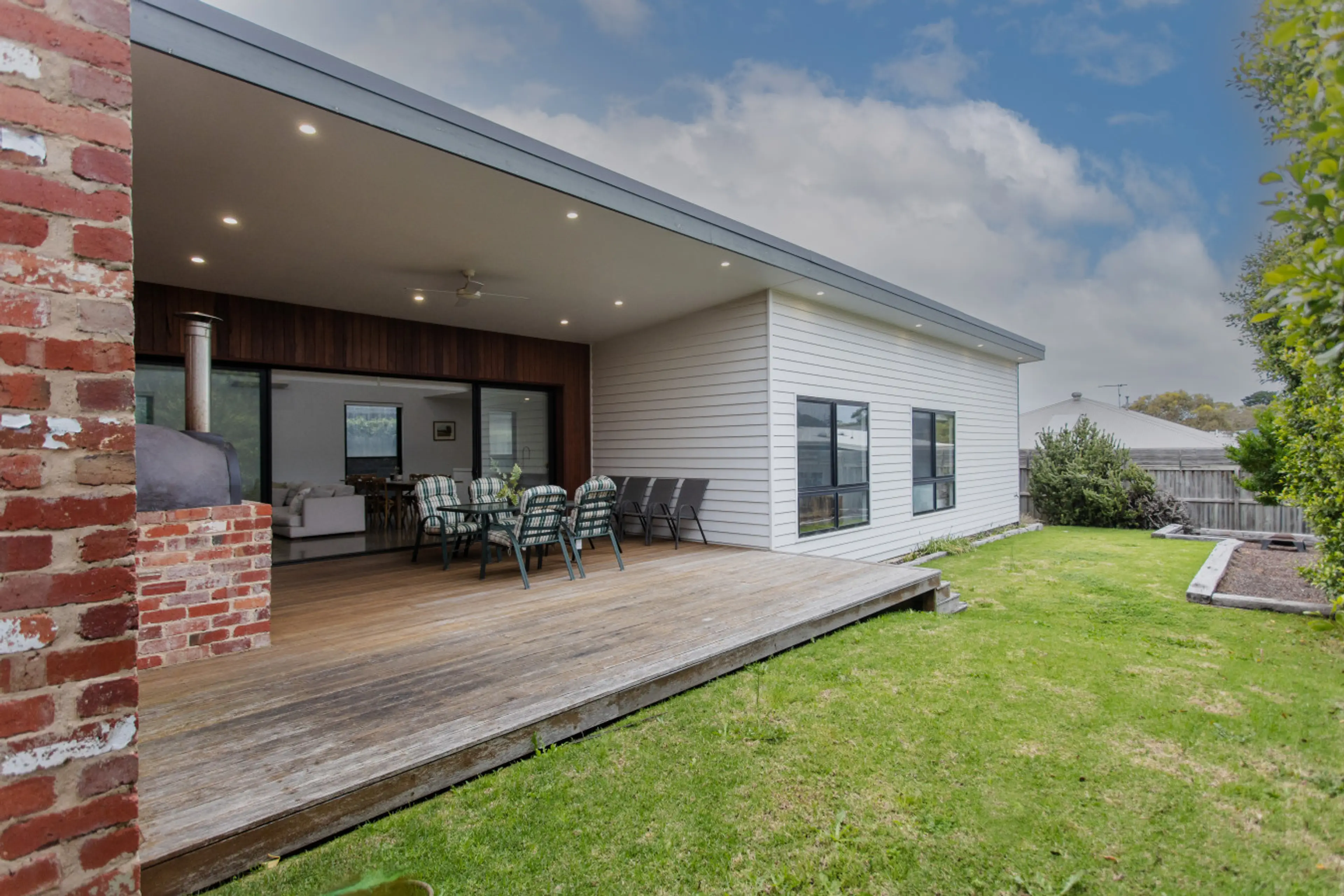 Big covered deck and a lovely grassy backyard — great for kids and outdoor get-togethers.