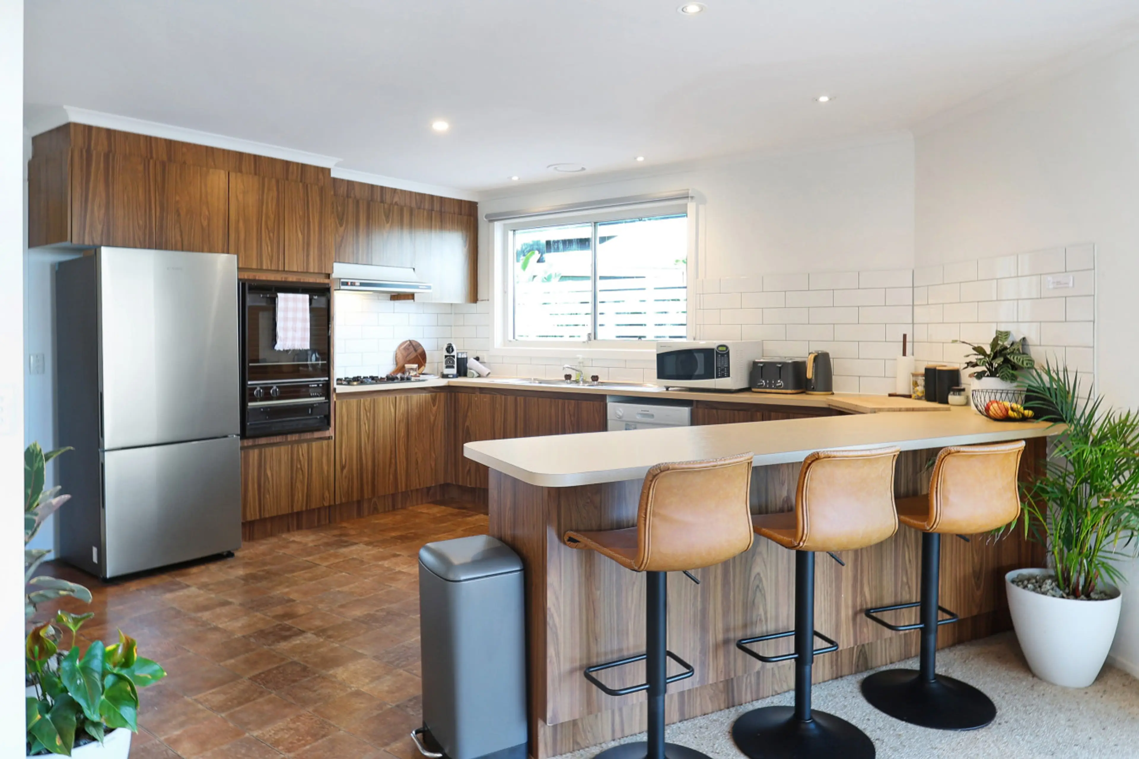 Warm timber kitchen with breakfast bar and modern essentials, practical and inviting