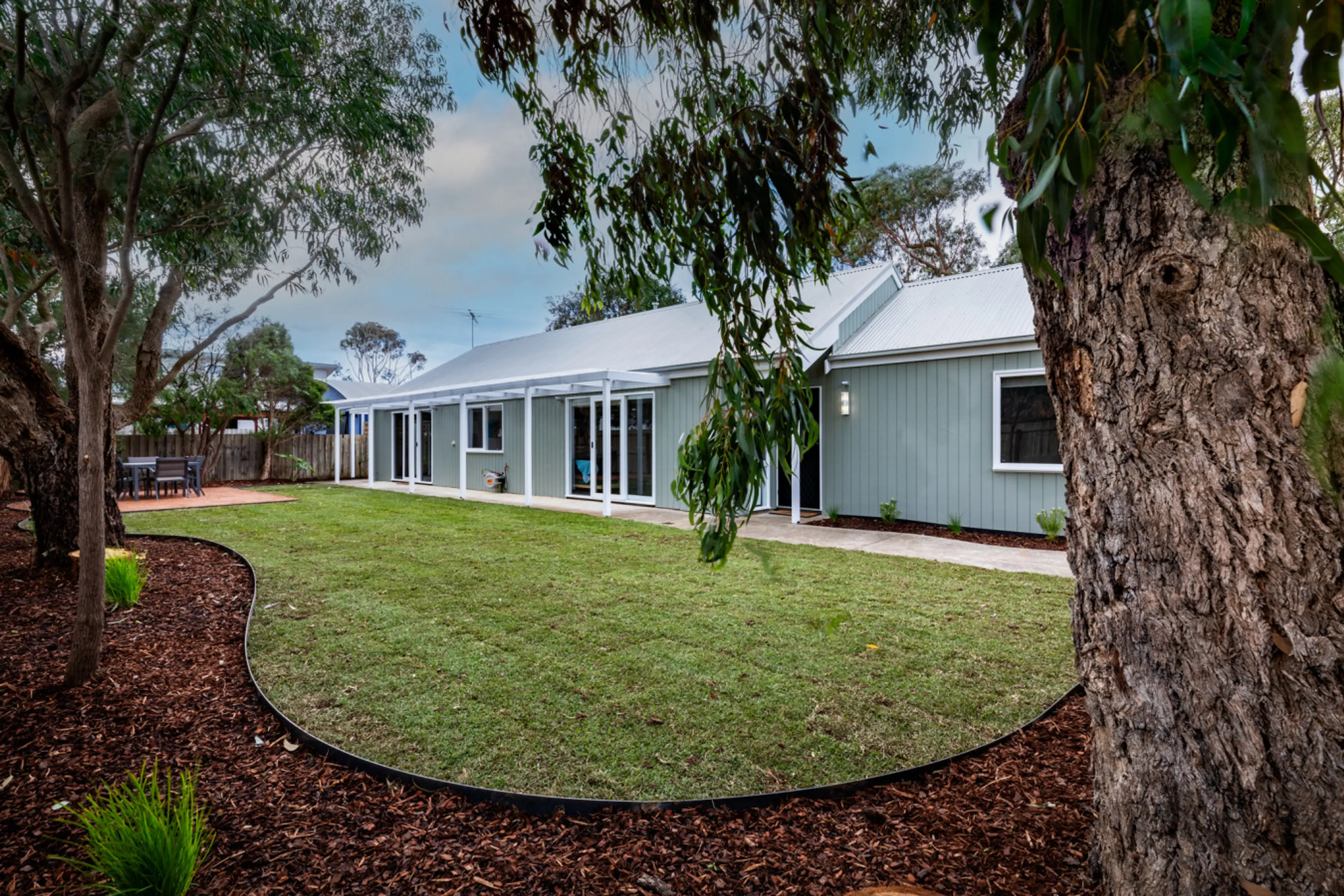 Spacious backyard with lush lawn and peaceful outdoor setting