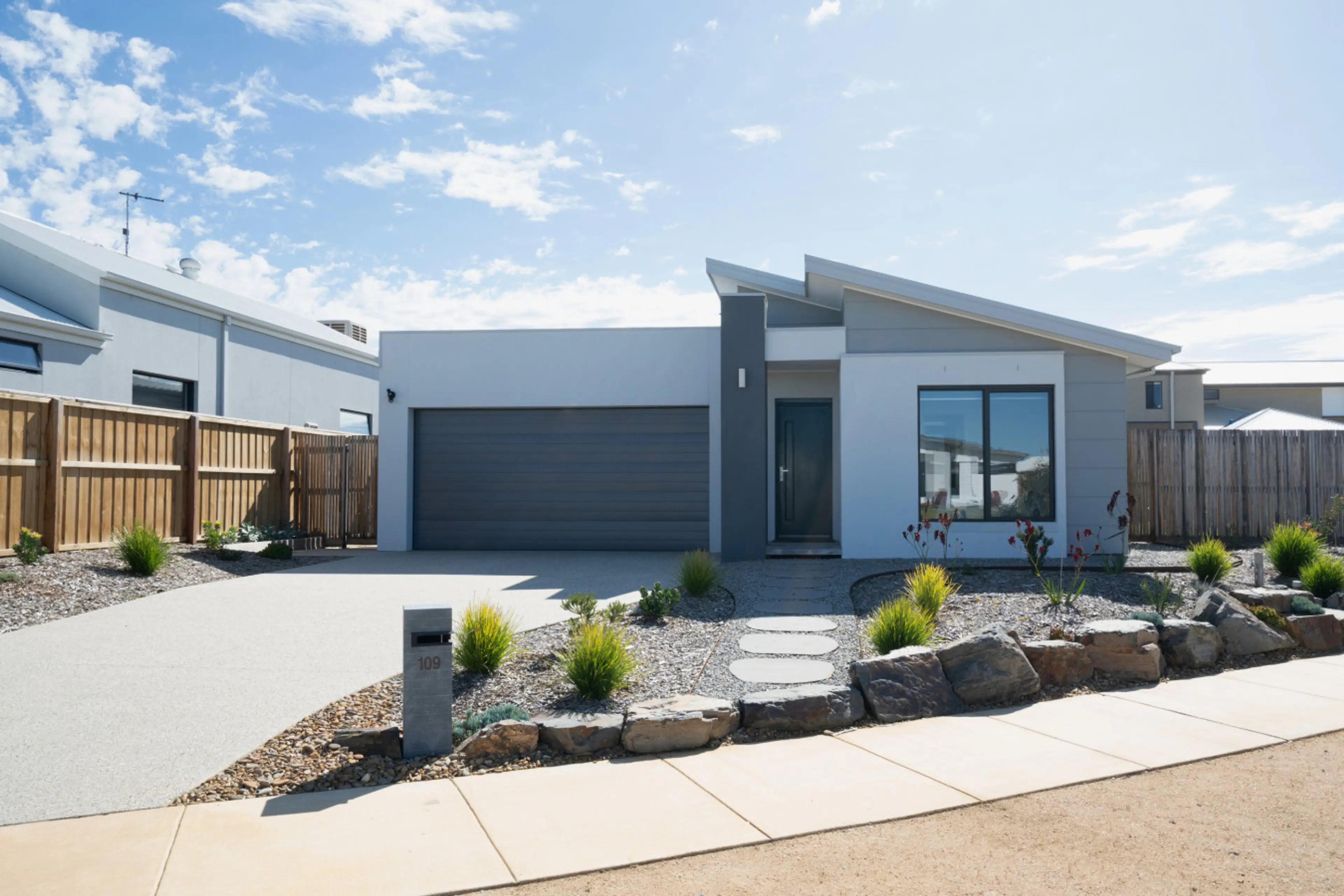 Clean, modern frontage with a welcoming driveway and landscaped entry.