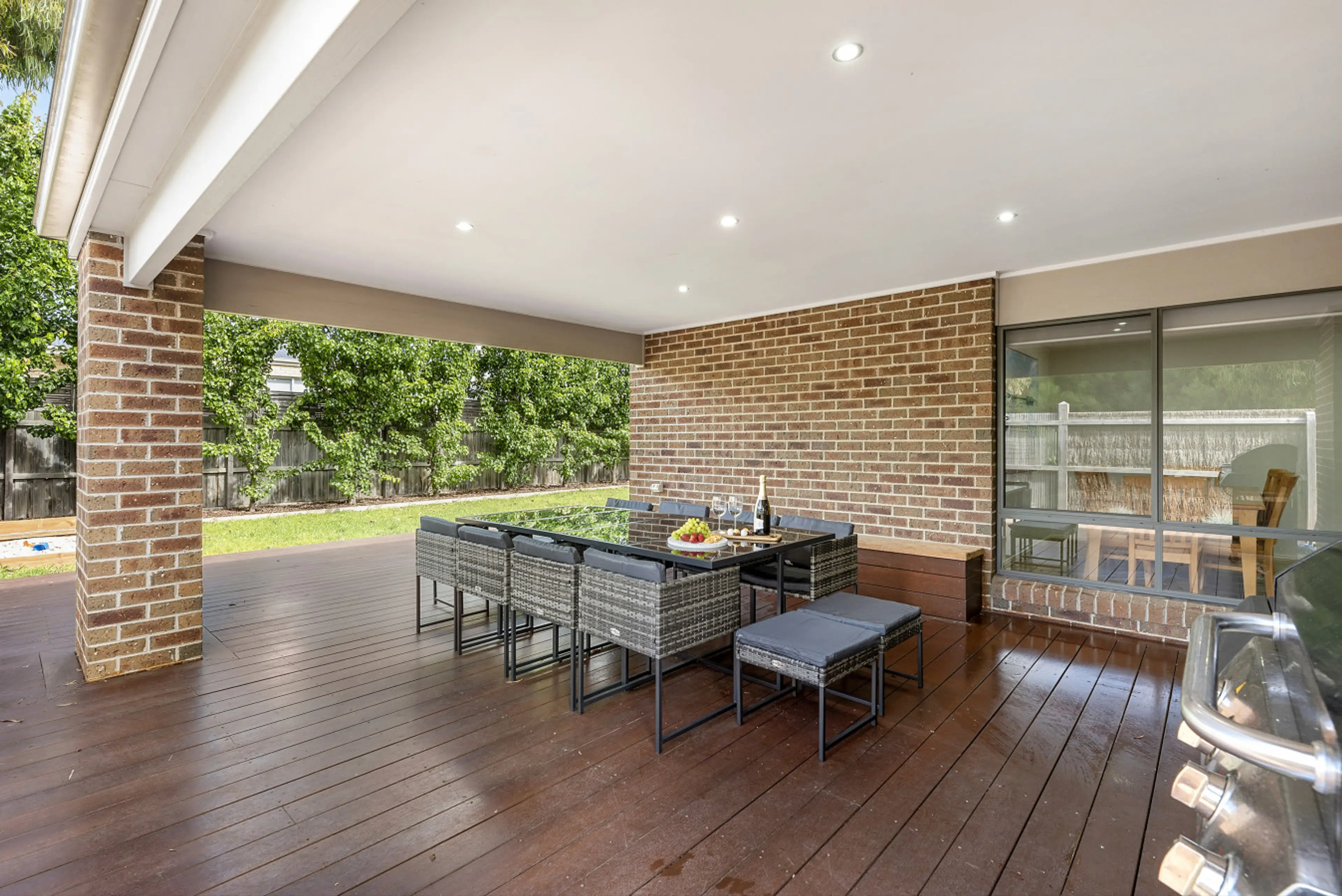 Covered outdoor deck with dining setup, perfect for alfresco meals.