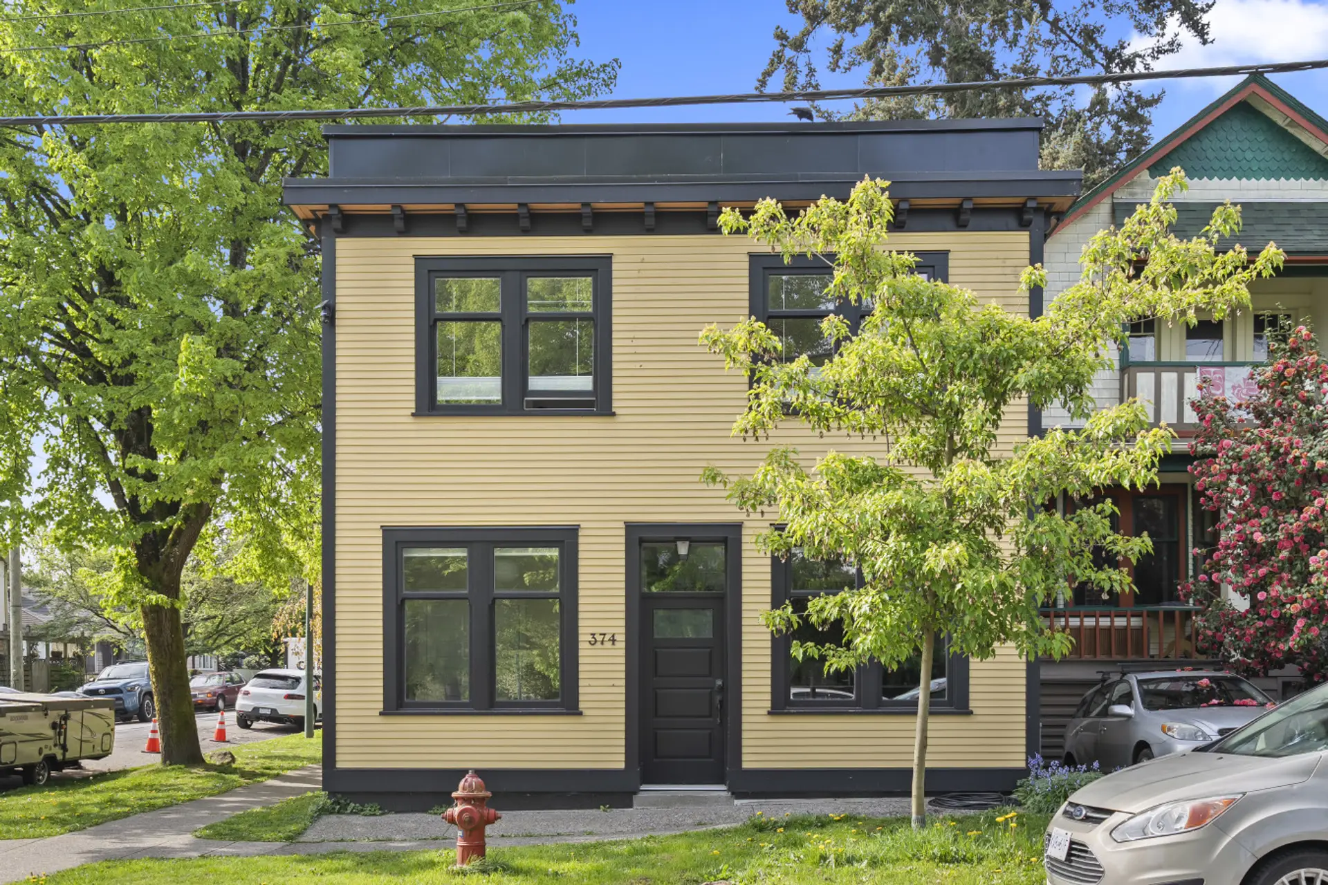 Bright yellow facade blends with nature, inviting you to explore vibrant Vancouver!