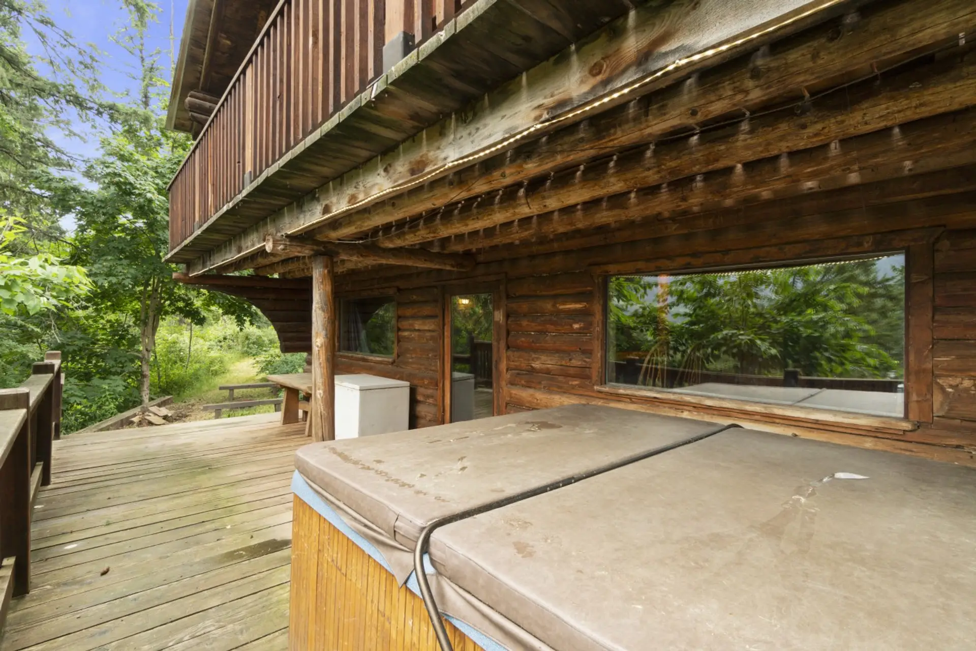 Private lower deck with hot tub, offering a cozy and secluded space to unwind.