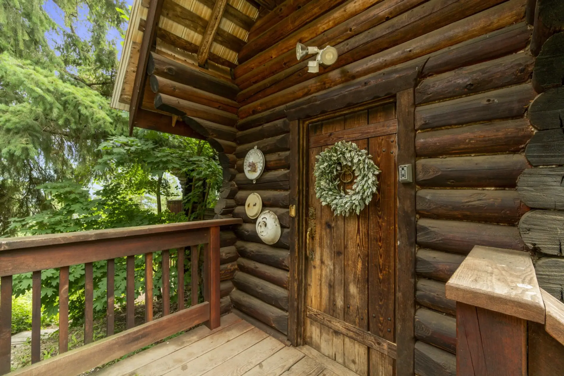 Welcoming cabin entrance with rustic wood details and a private deck nestled in the trees.