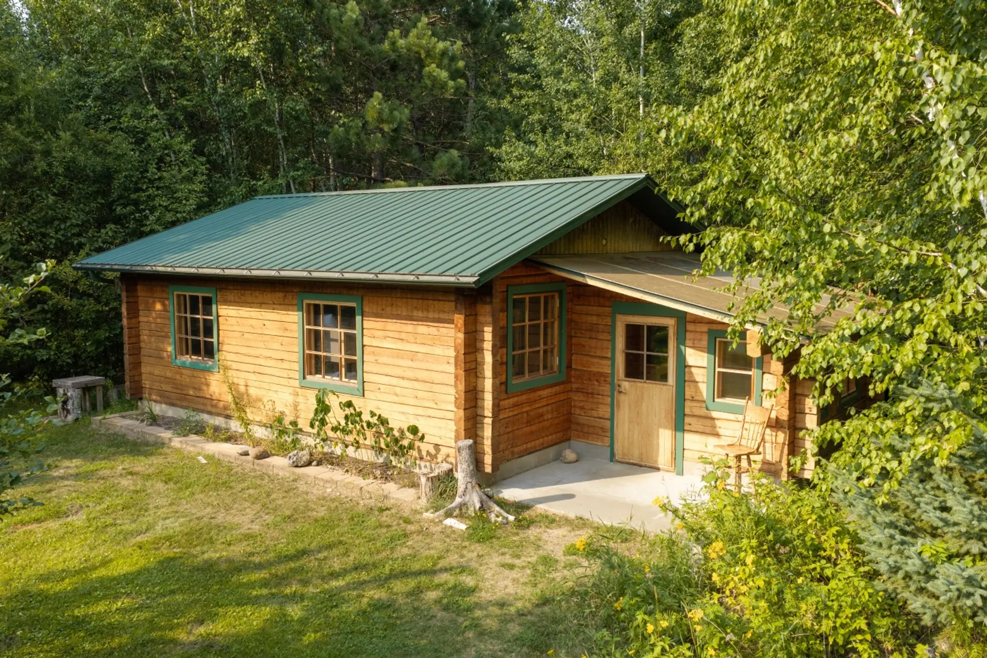 The Artist's Cabin sits on the edge of the back lawn clearing in the northern Minnesota woods, about a three-minute walk from the main lake house.