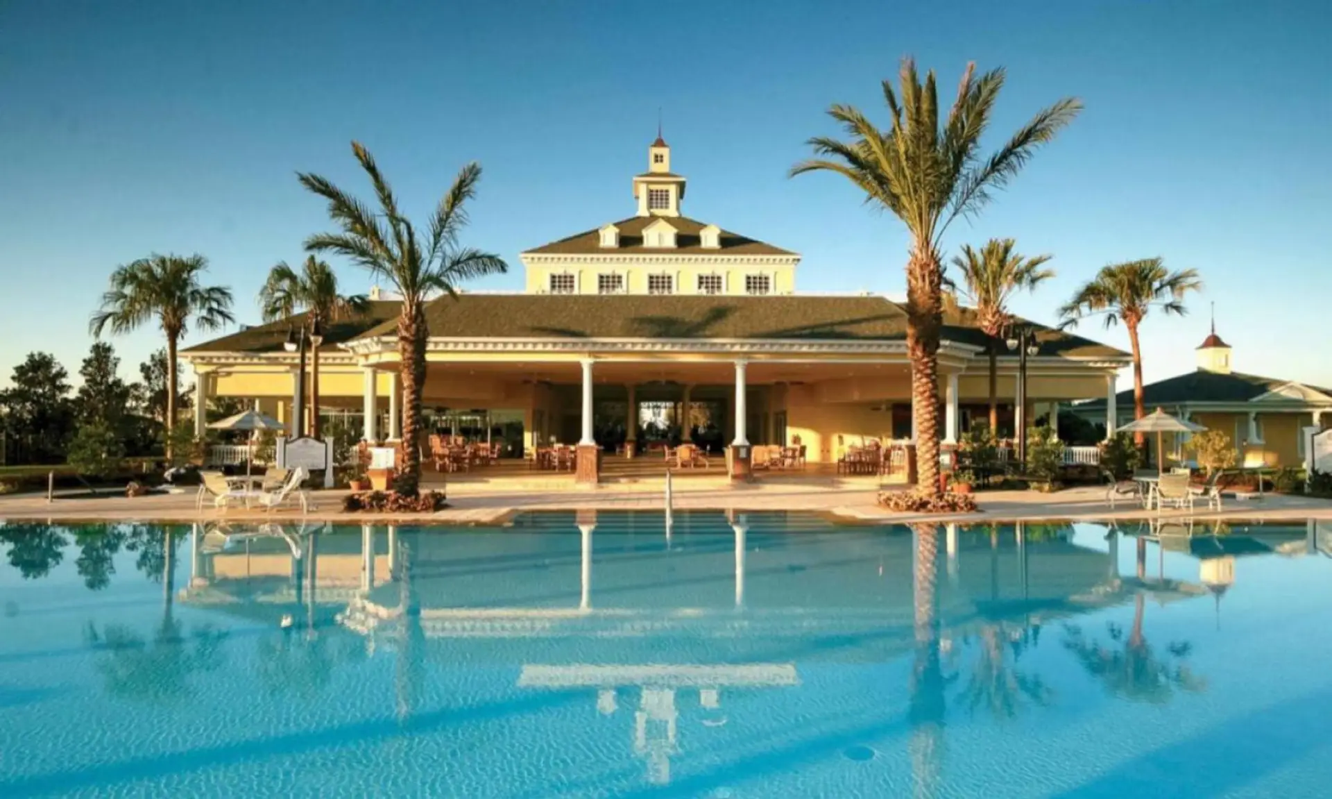 Sparkling blue pool perfect for swimming and sunbathing in a peaceful resort setting.