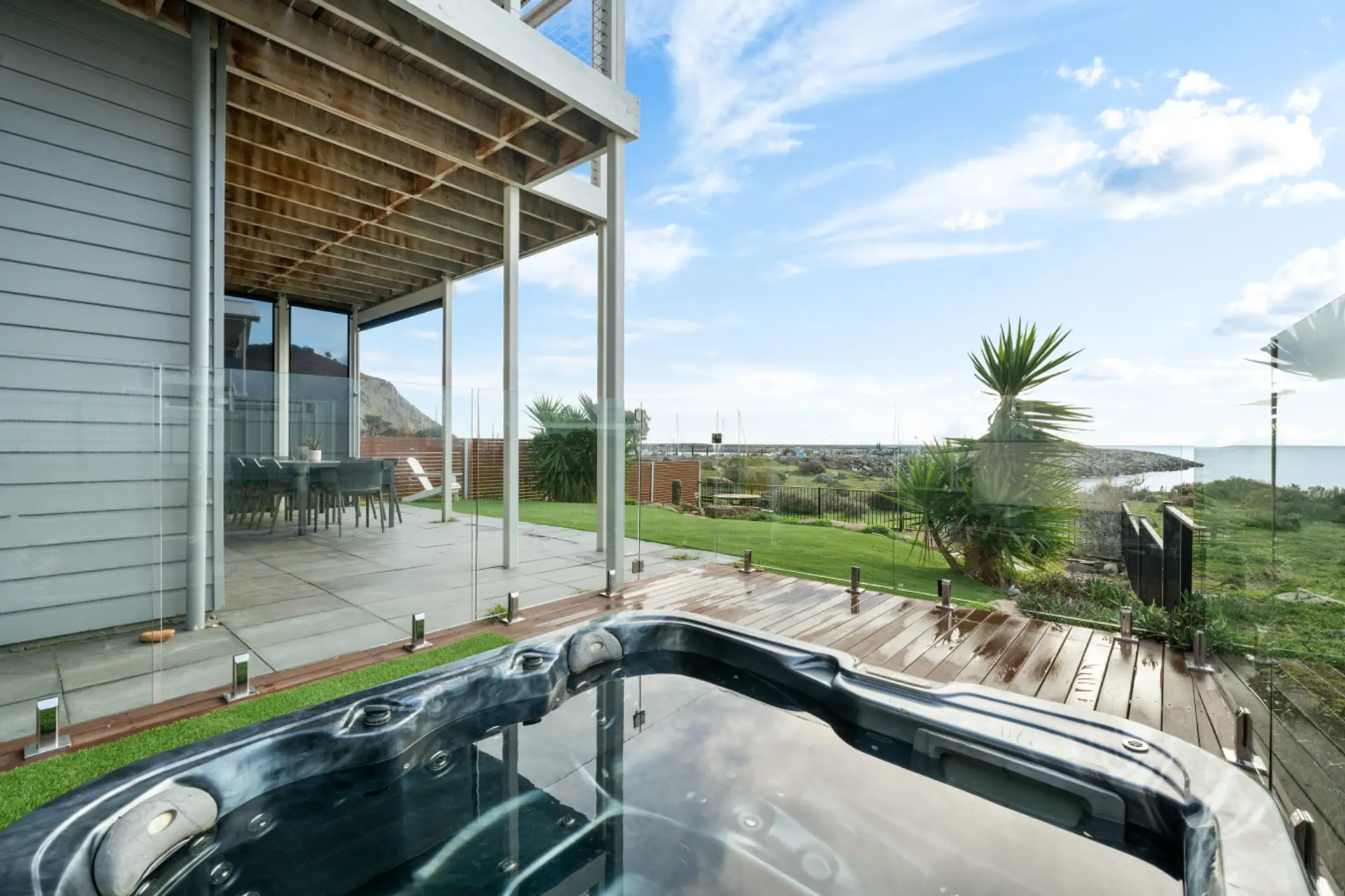Enjoy a rejuvenating soak in the private spa with stunning views over greenery and the ocean.