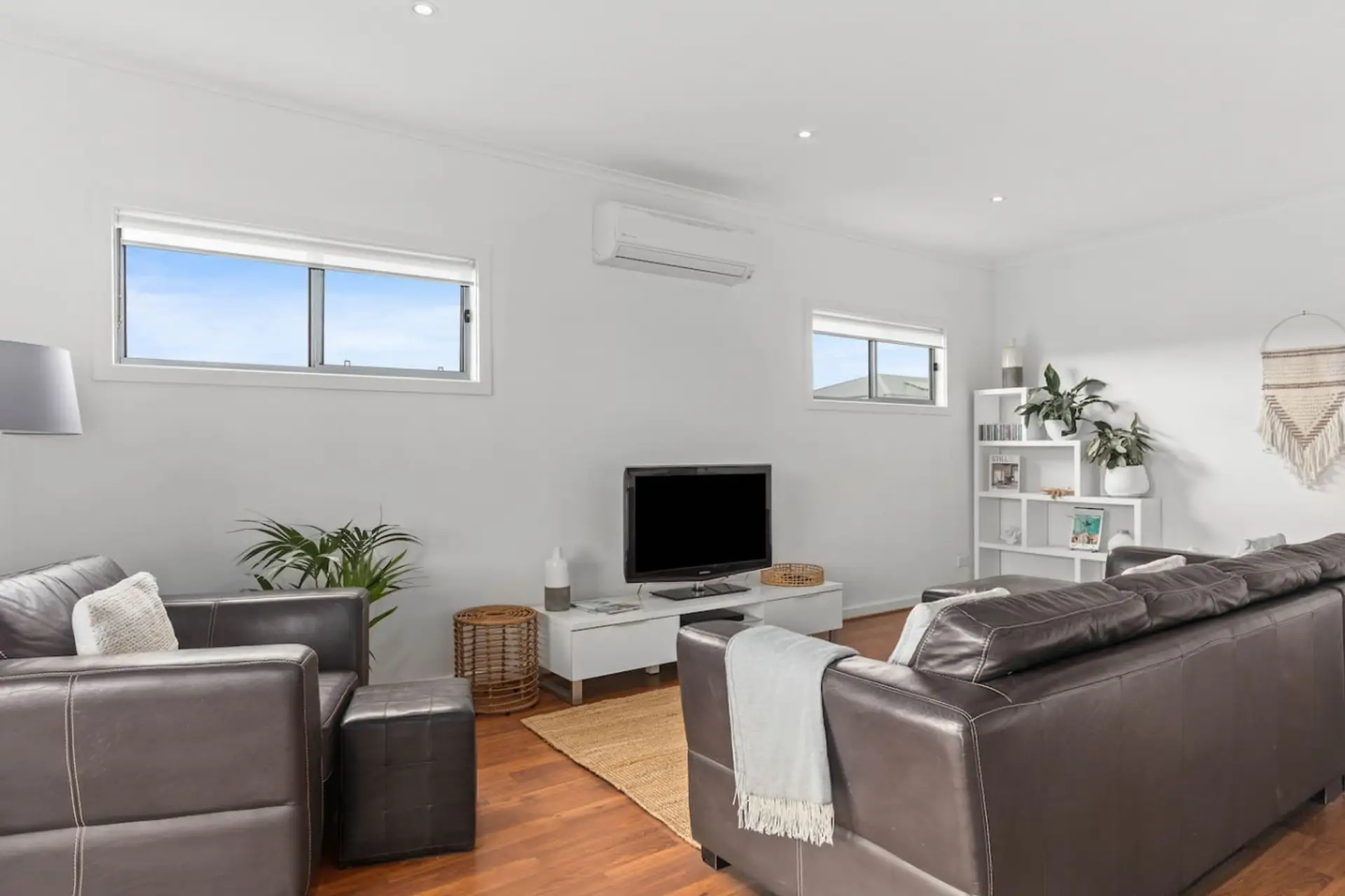Bask in natural light upstairs as you unwind in a bright, open living area featuring plush leather seating, countryside glimpses, and seamless access to the dining area and balcony.