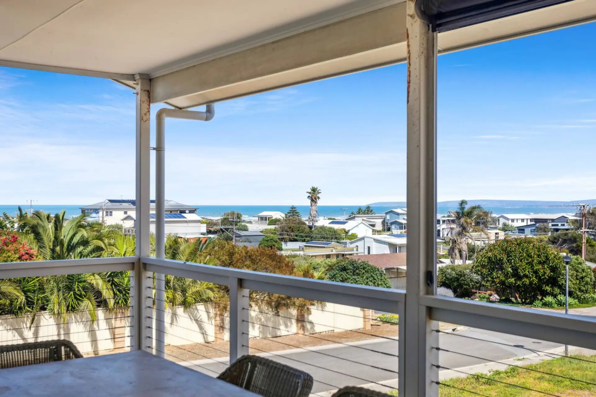 Wide glass doors open to the balcony, where leafy outlooks and sea glimpses create a tranquil backdrop for morning coffee or sunset BBQs.