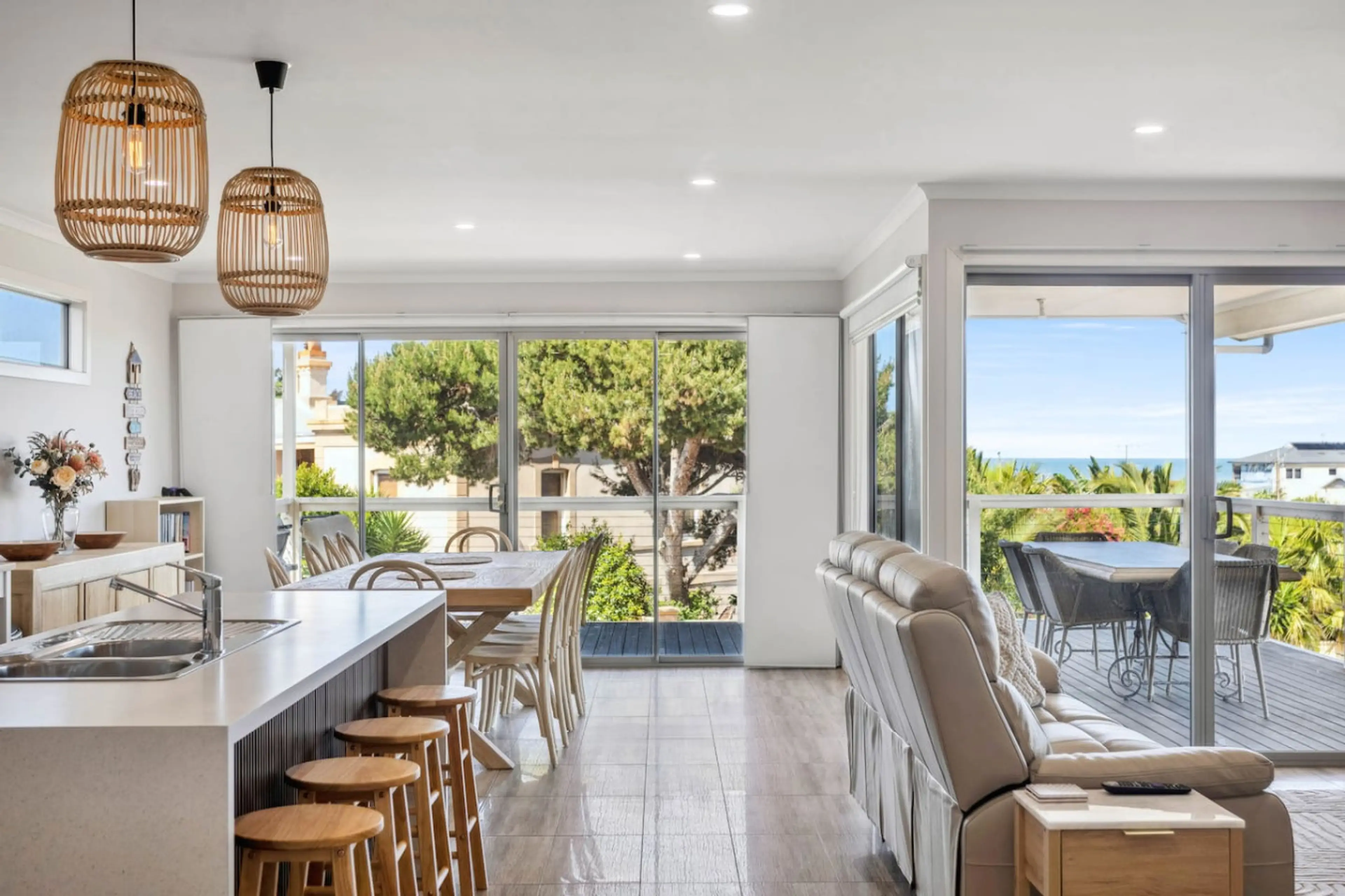 Upstairs, the open-plan layout connects the kitchen, dining, and lounge areas, flowing effortlessly onto the balcony for easy indoor–outdoor living.