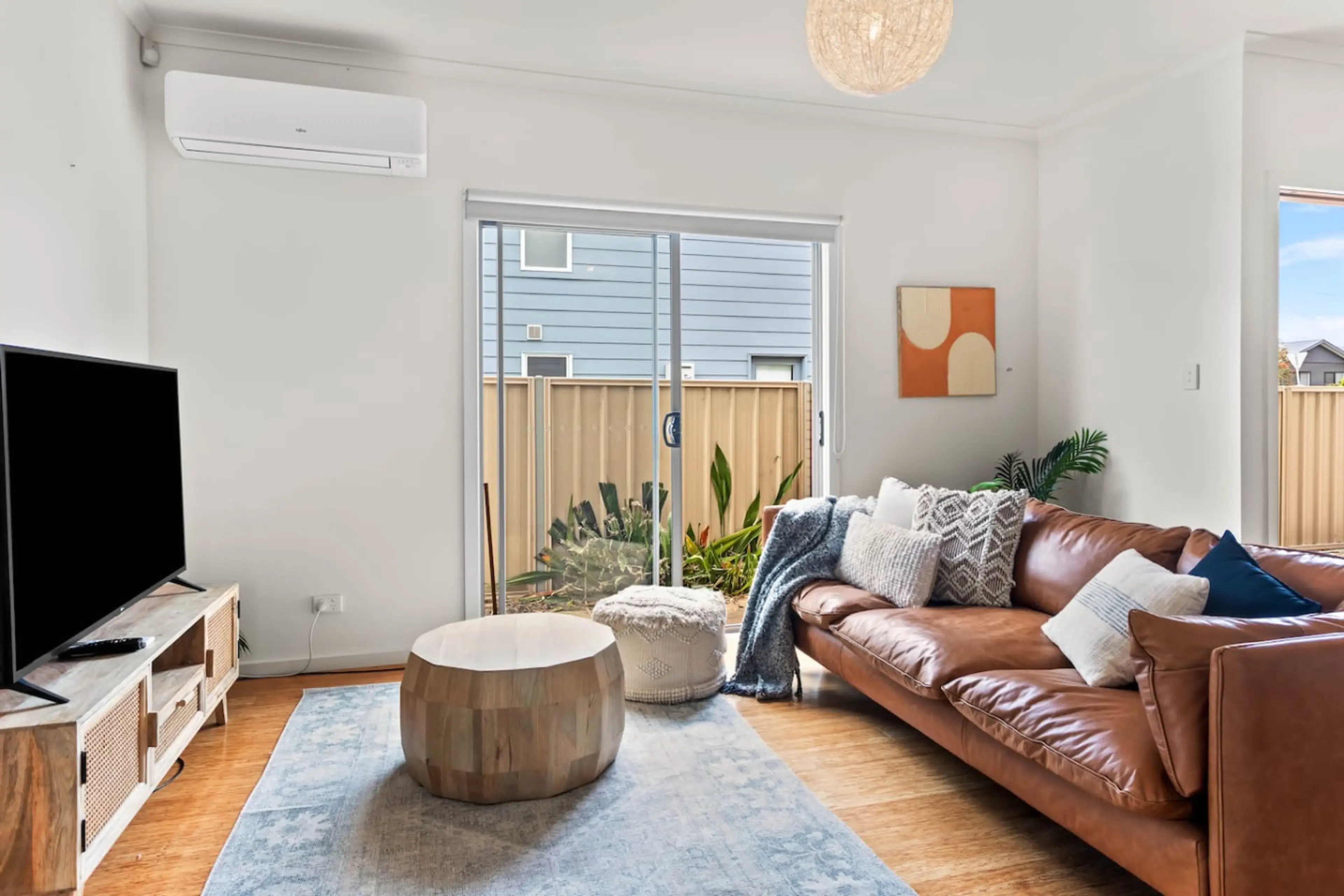 A private haven for movie nights, the downstairs living area features a leather sofa, soft lighting, and a large TV for relaxed family entertainment.