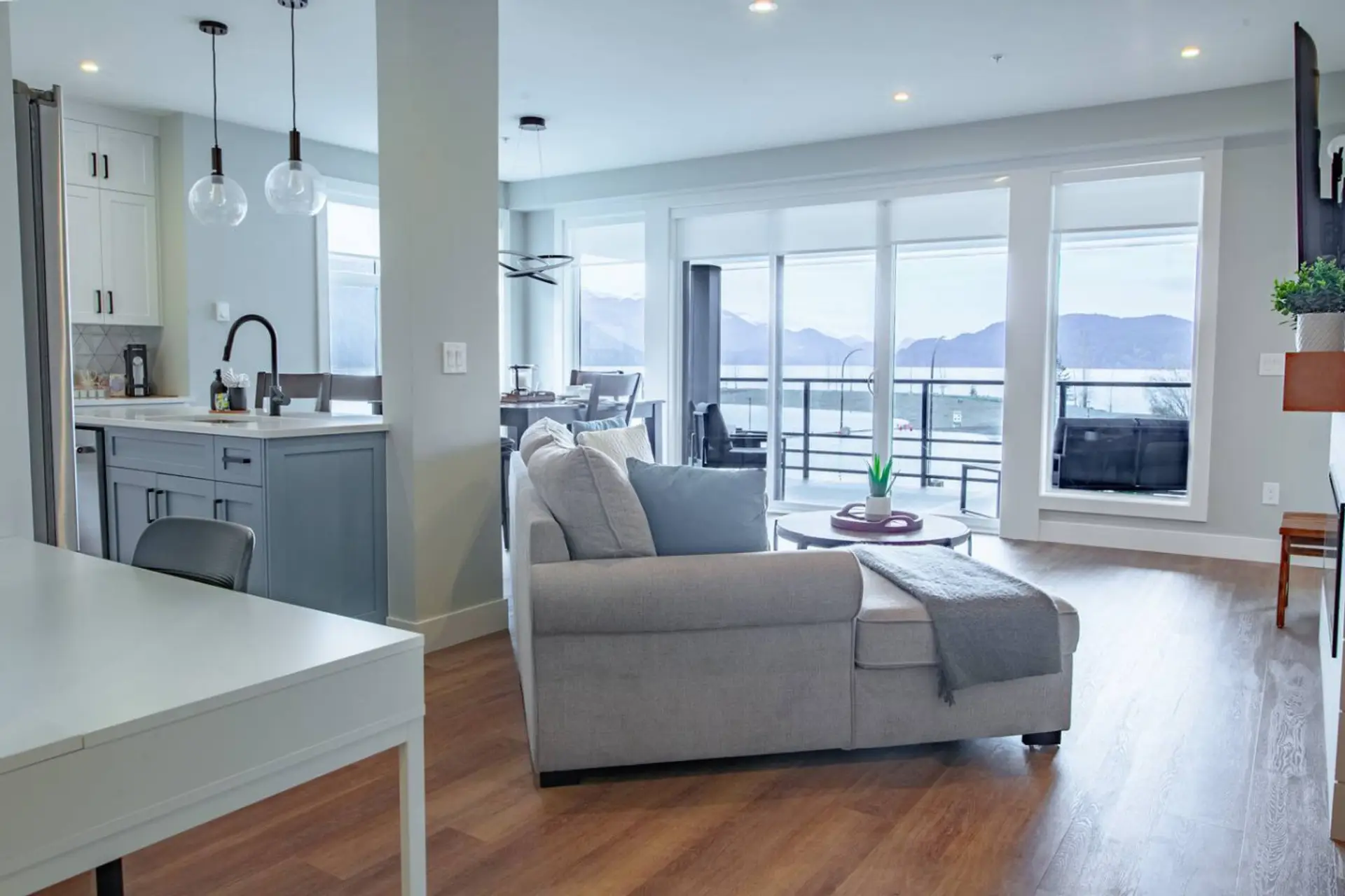Relax in the living room with panoramic views of Harrison Lake and the mountains.