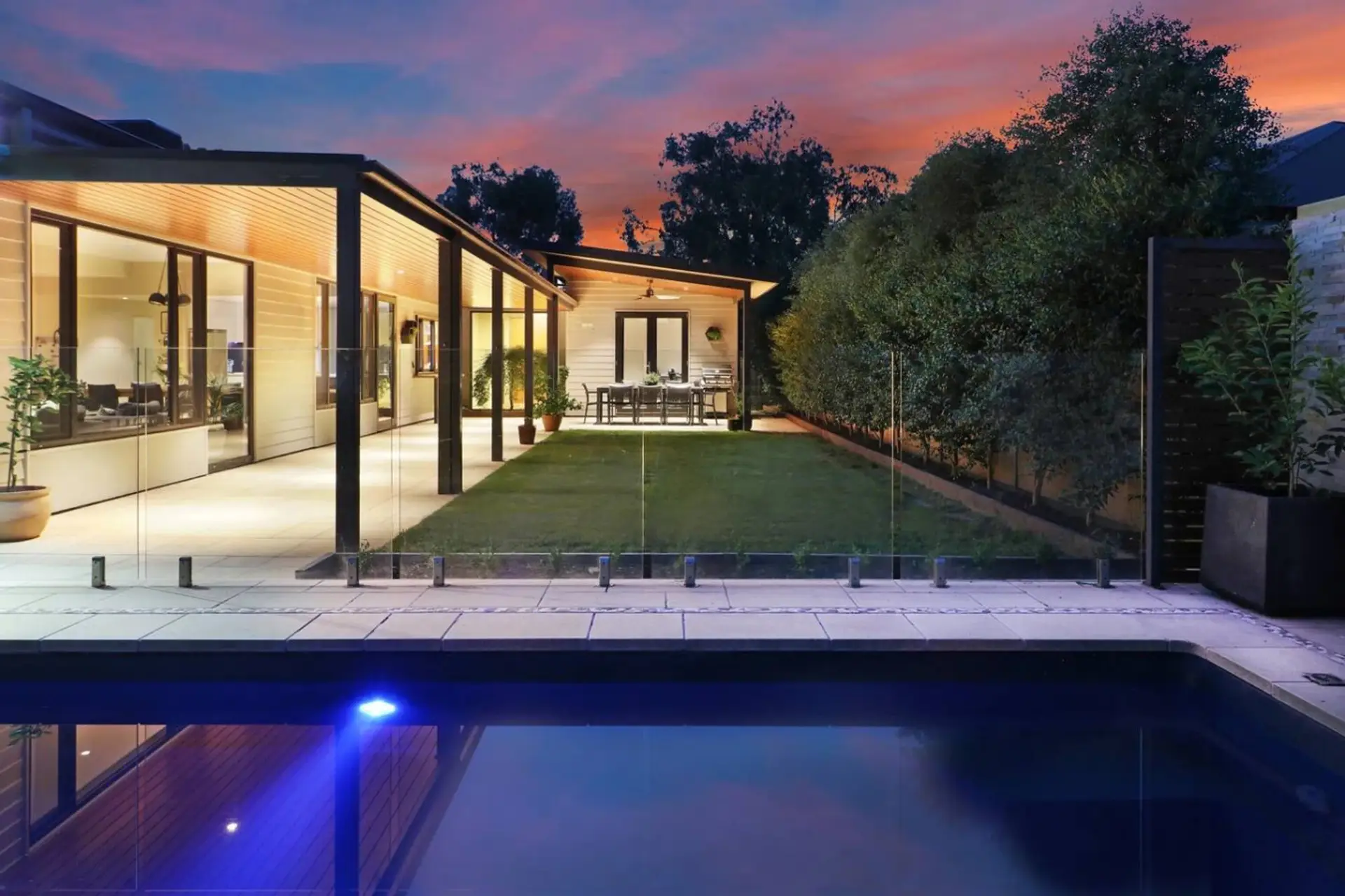 A private, fully fenced backyard featuring a level lawn, covered alfresco dining and swimming pool—perfect for relaxed High Country stays at Banksia House.