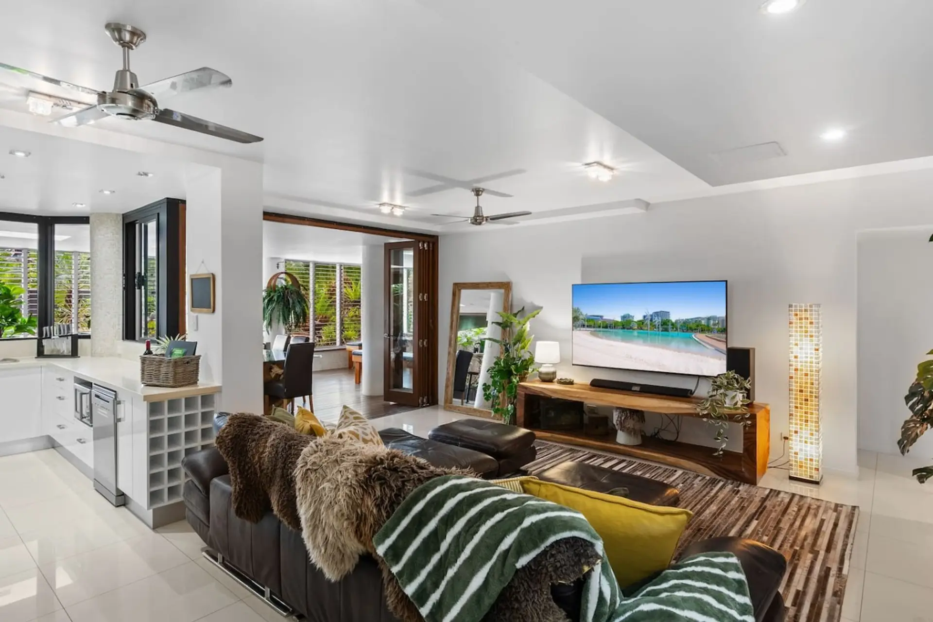 Bright open plan living connects the modern kitchen, lounge and indoor outdoor spaces. Relax on the spacious leather sofa, stream your favourites on the smart TV, and enjoy air conditioning, ceiling fans and a welcoming, light filled atmosphere.