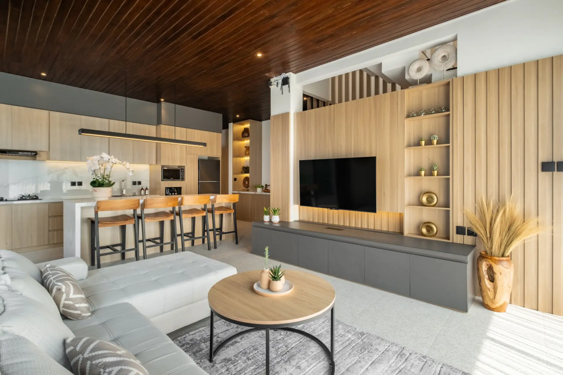 Modern  living space with wood accents, pool view, and sleek kitchen.