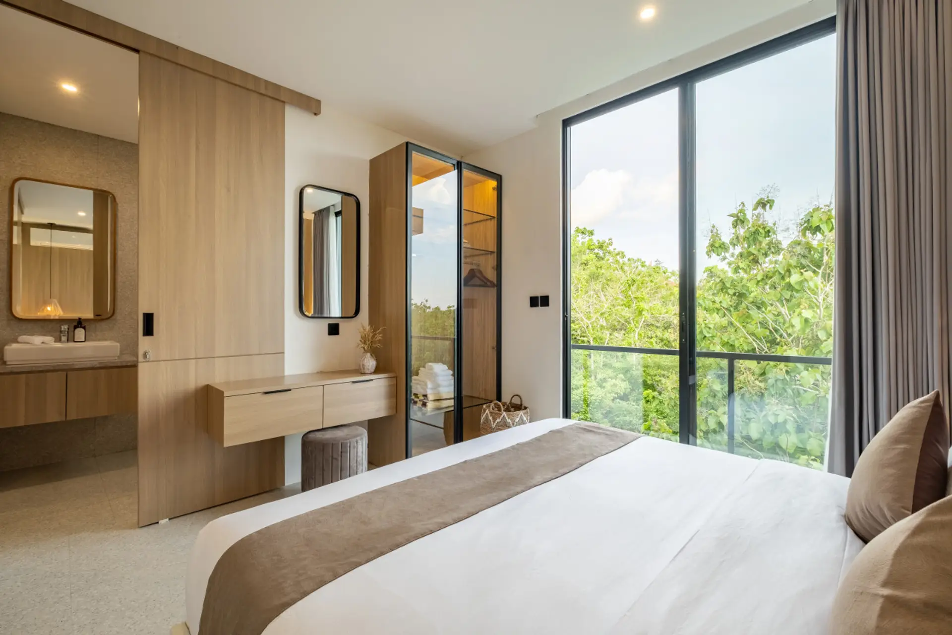Bright and cozy bedroom with a panoramic green view and natural wood accents.