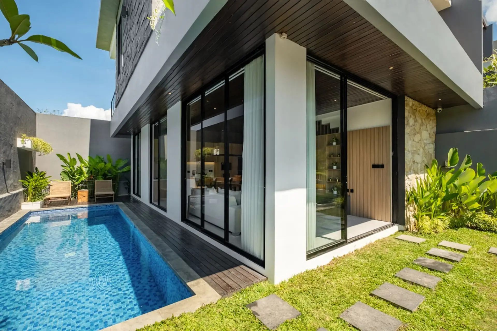 Private villa with a stylish pool and lush garden view.