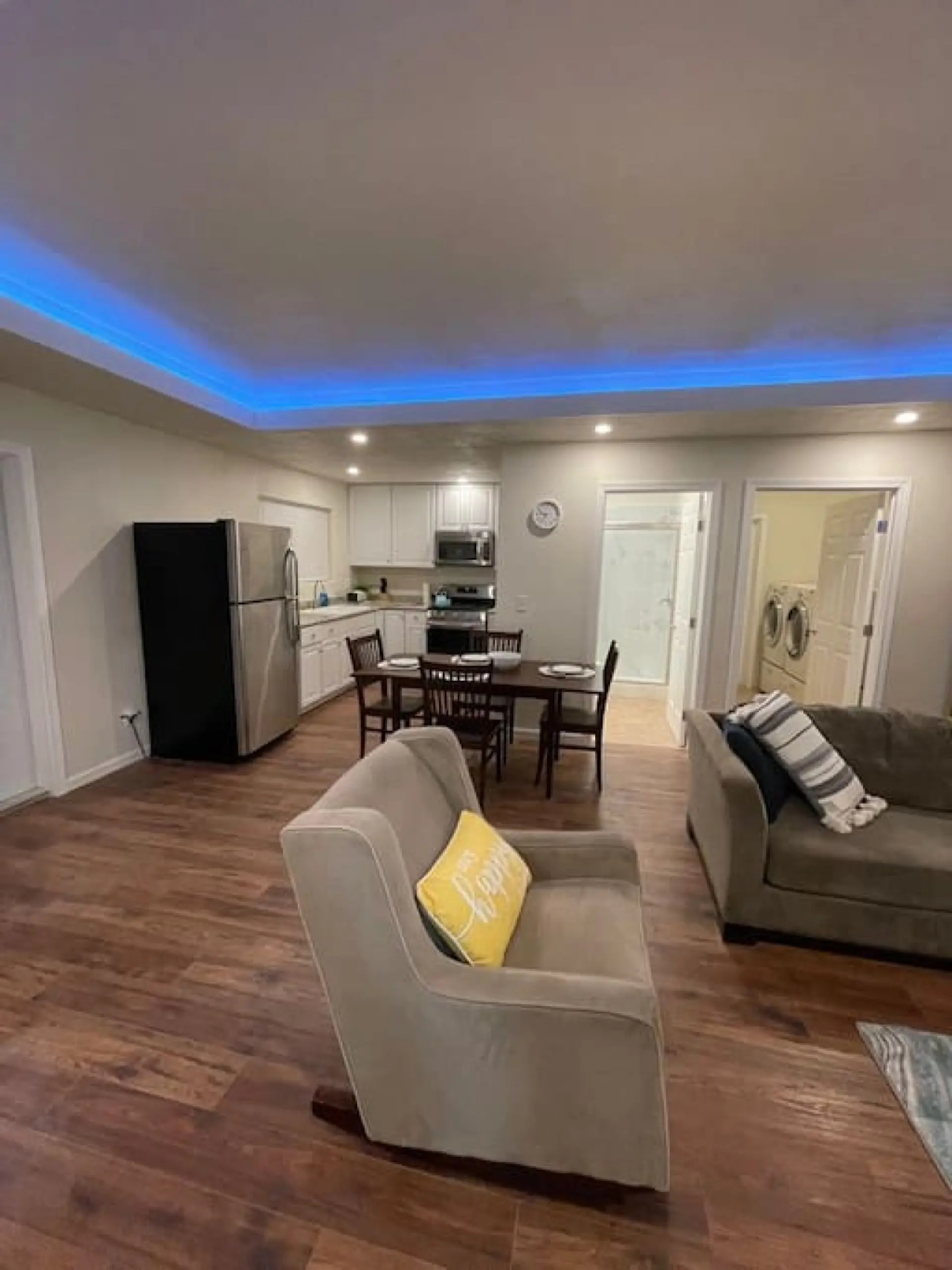 The open living area features a modern kitchen, dining space, and comfortable seating.