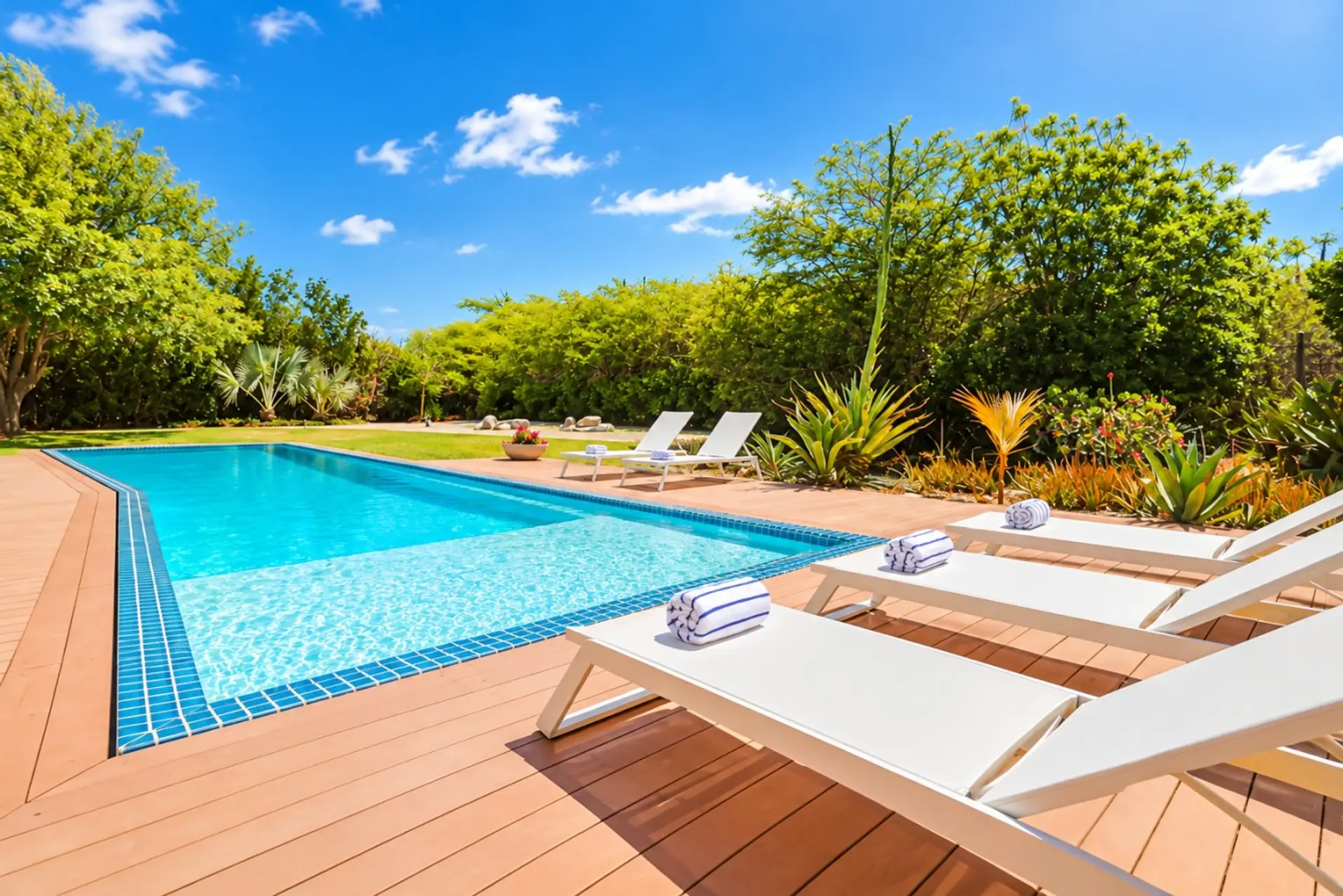 A stunning expansive landscaped private backyard garden, with your own large swimming pool, chaise sun loungers, BBQ, outside TV and a comfortable shaded patio terrace dining and seating area - a great space for enjoying time with family and friends.