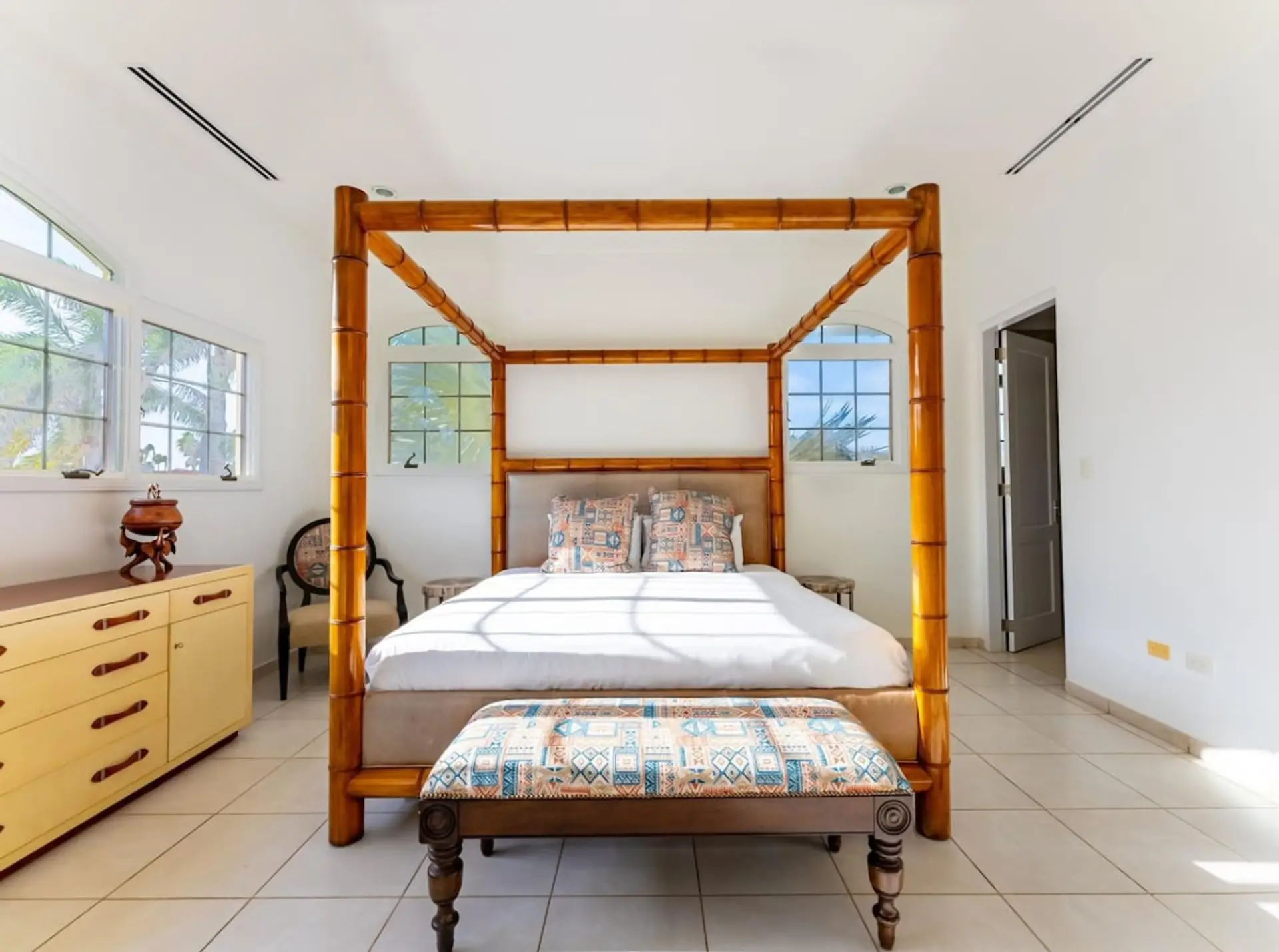 Master Bedroom | Experience ultimate comfort in the master bedroom at Seaside Beach House, featuring a plush bed, TV, walk-in closet, and a luxurious ensuite bathroom.
