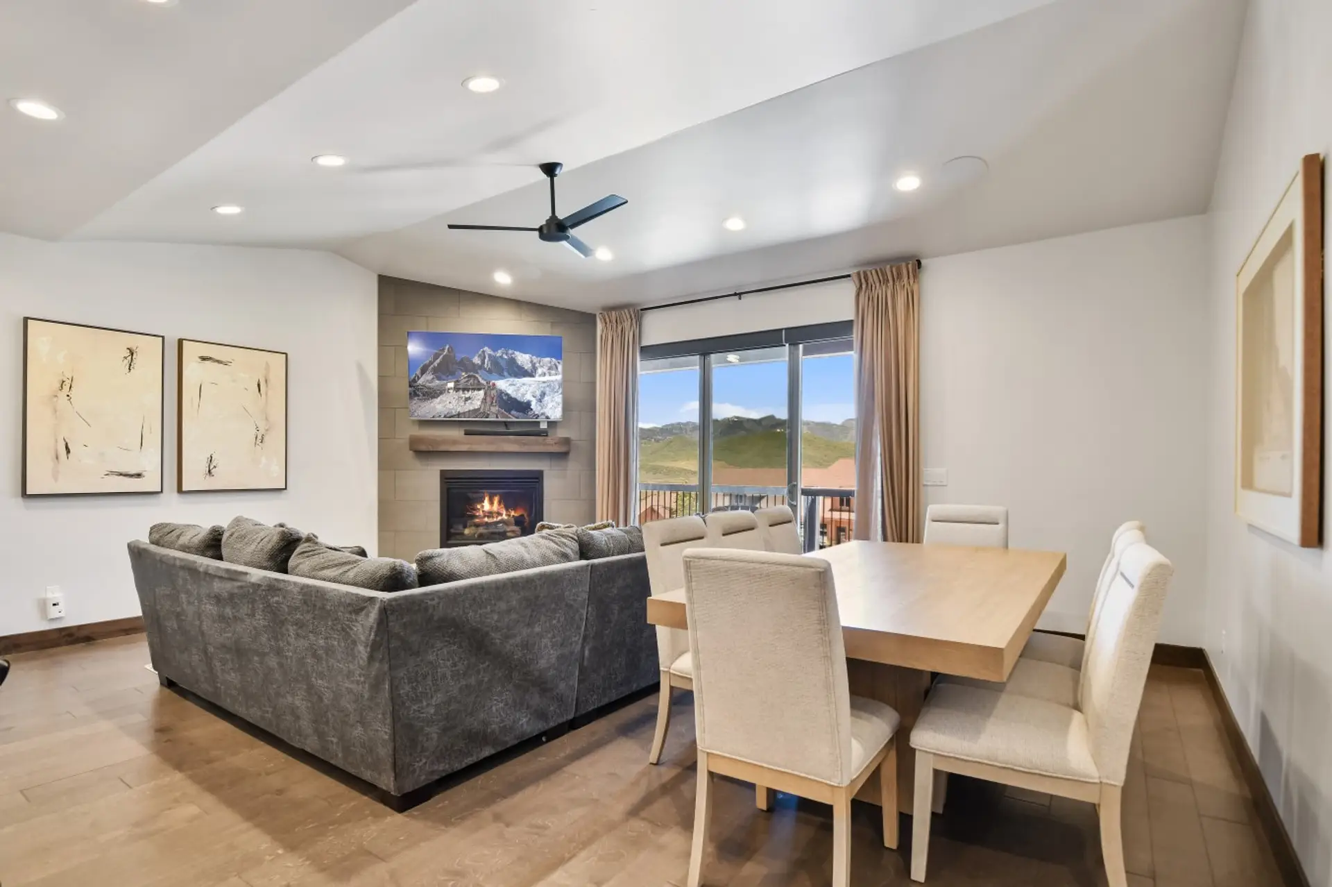 Inviting living room with a cozy sofa, outdoor access to the deck, and stunning views of the mountains.