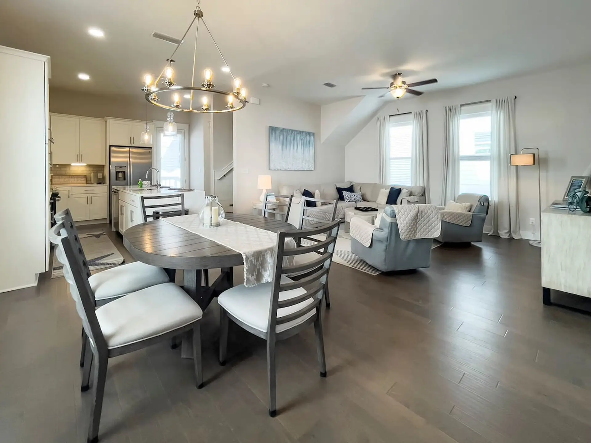 Modern open-concept living with marble counters, spacious dining, bar seating, and a comfy lounge with smart TV + soundbar.