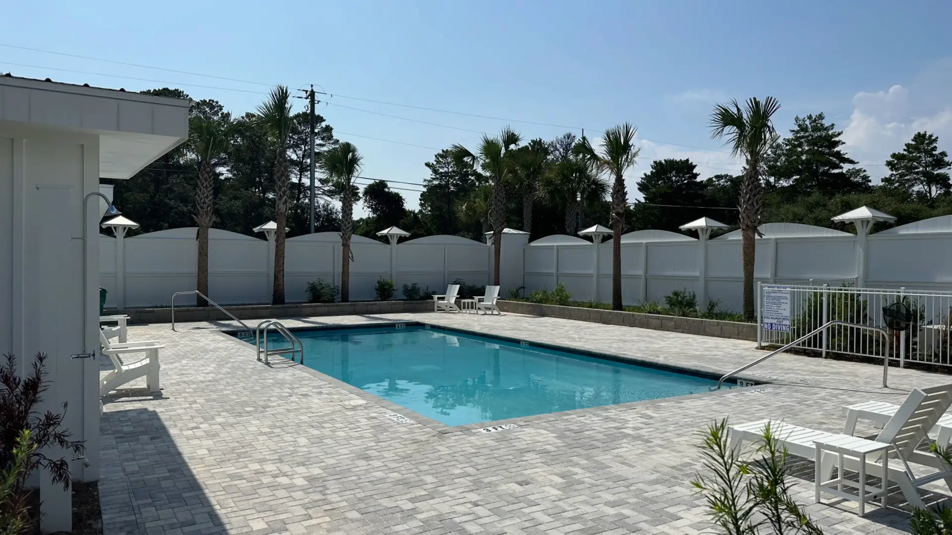 The Ivy neighborhood pool with sunny seating, loungers, and convenient bathroom access.
