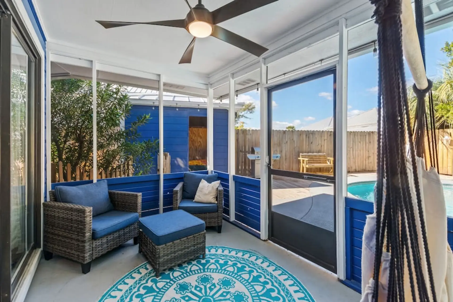 The queen master opens to a private screened poolside patio featuring comfortable seating and a hammock, offering a serene space to unwind and enjoy the outdoors in privacy.