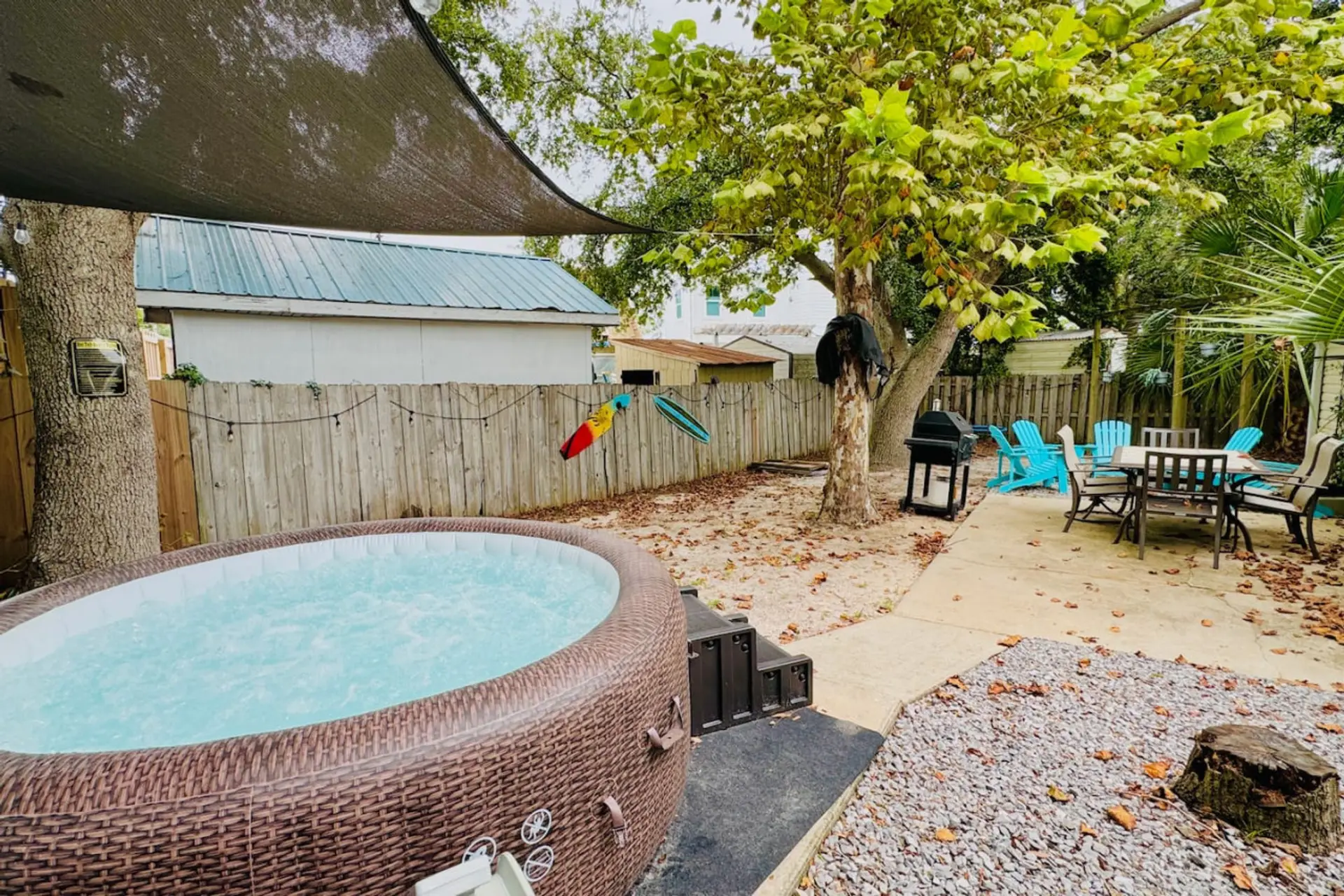 Step into a backyard oasis featuring a hot tub and a comfortable seating area, ideal for peaceful evenings or entertaining.