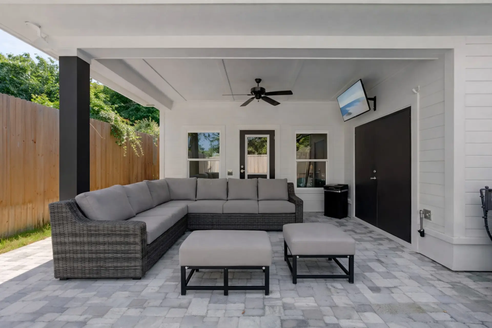 Kick back on the covered patio with a comfy sectional, ceiling fan, and wall-mounted TV—your own outdoor living room for lazy mornings and game nights.