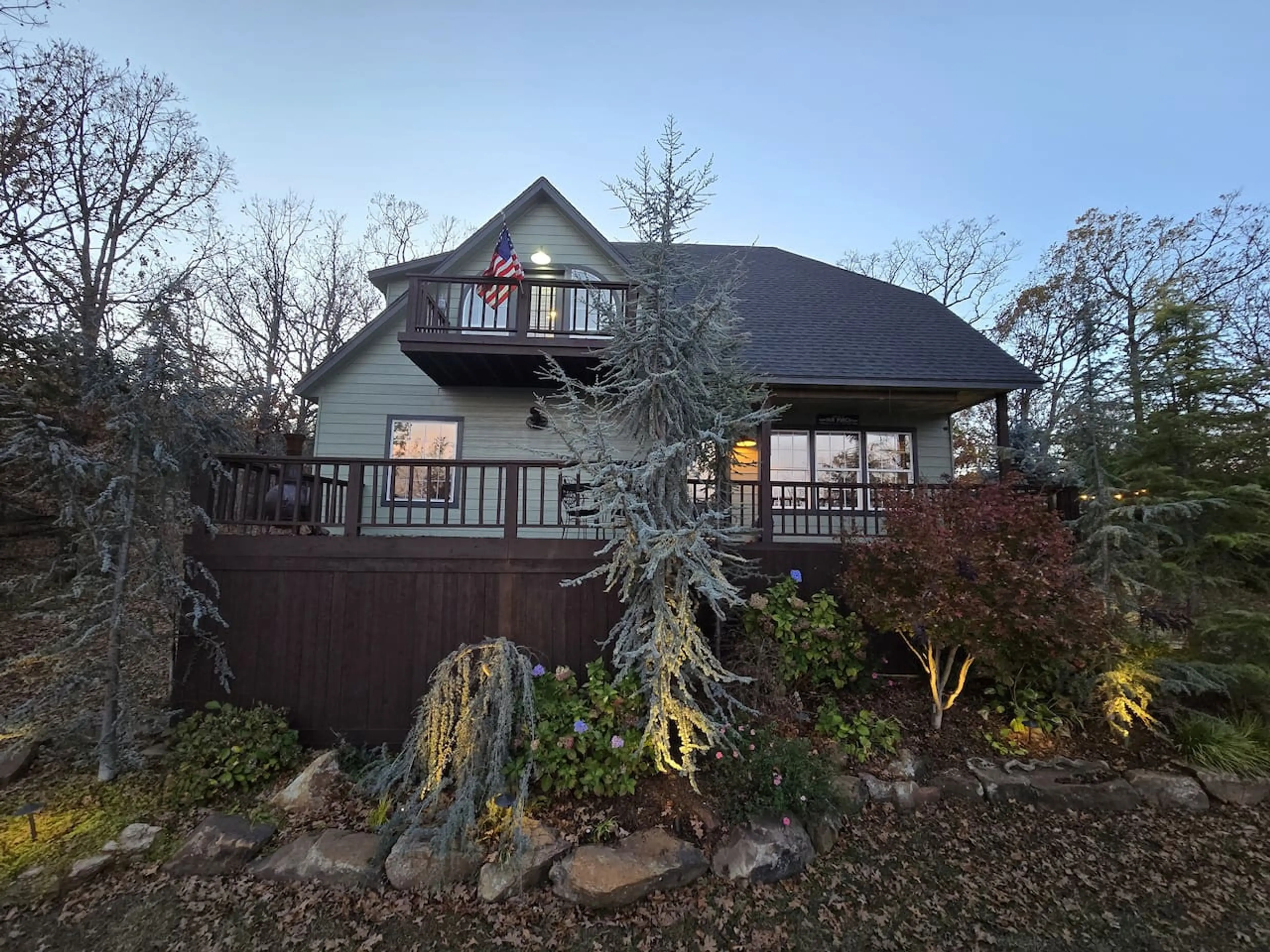 The home lights the landscaping beautifully as the sun goes down.