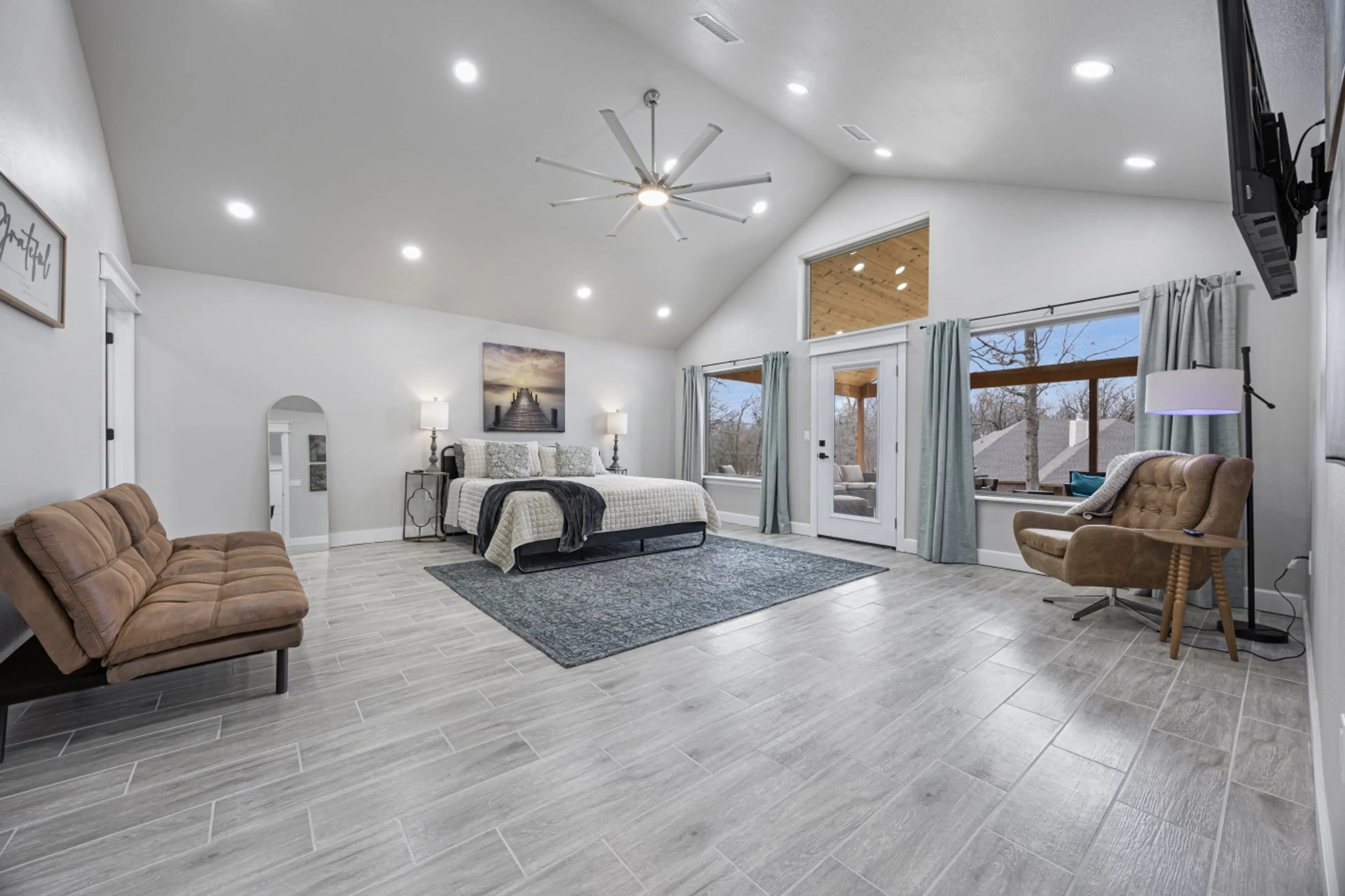 Primary bedroom with king bed, ensuite bathroom with shower, and access to the covered porch