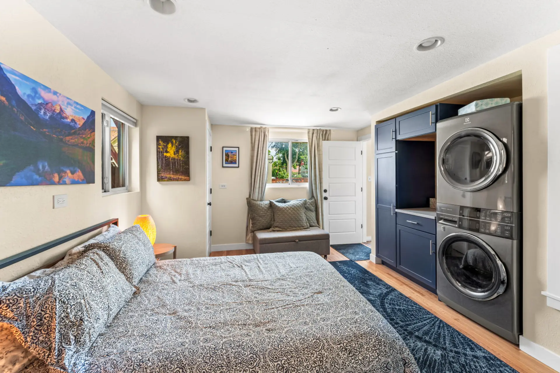 Primary bedroom with queen bed, smart TV, and washer/dryer