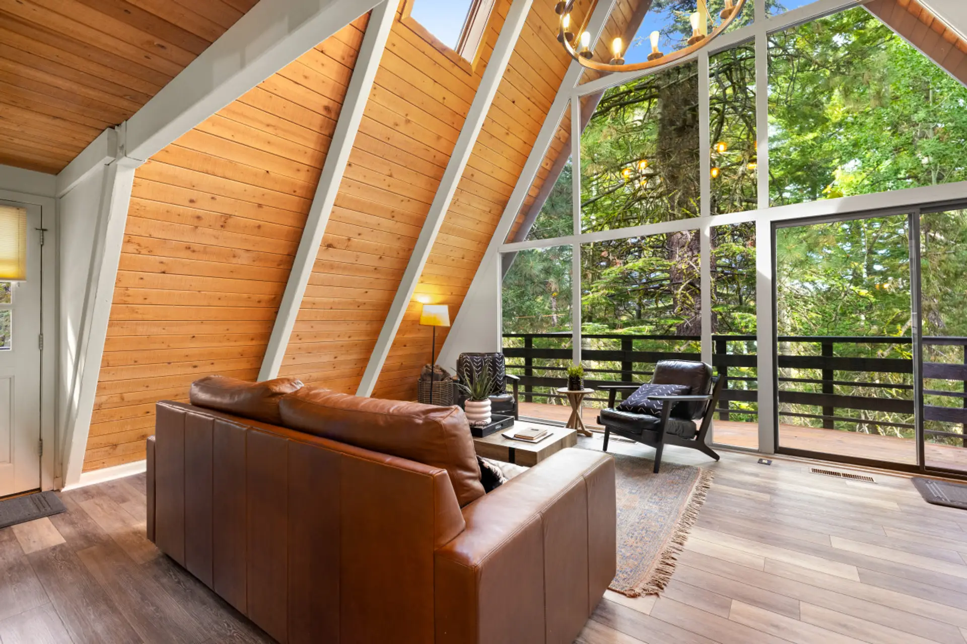 A-frame living room with leather sofa and chairs begging for you to relax with a book, a drink, or a puzzle