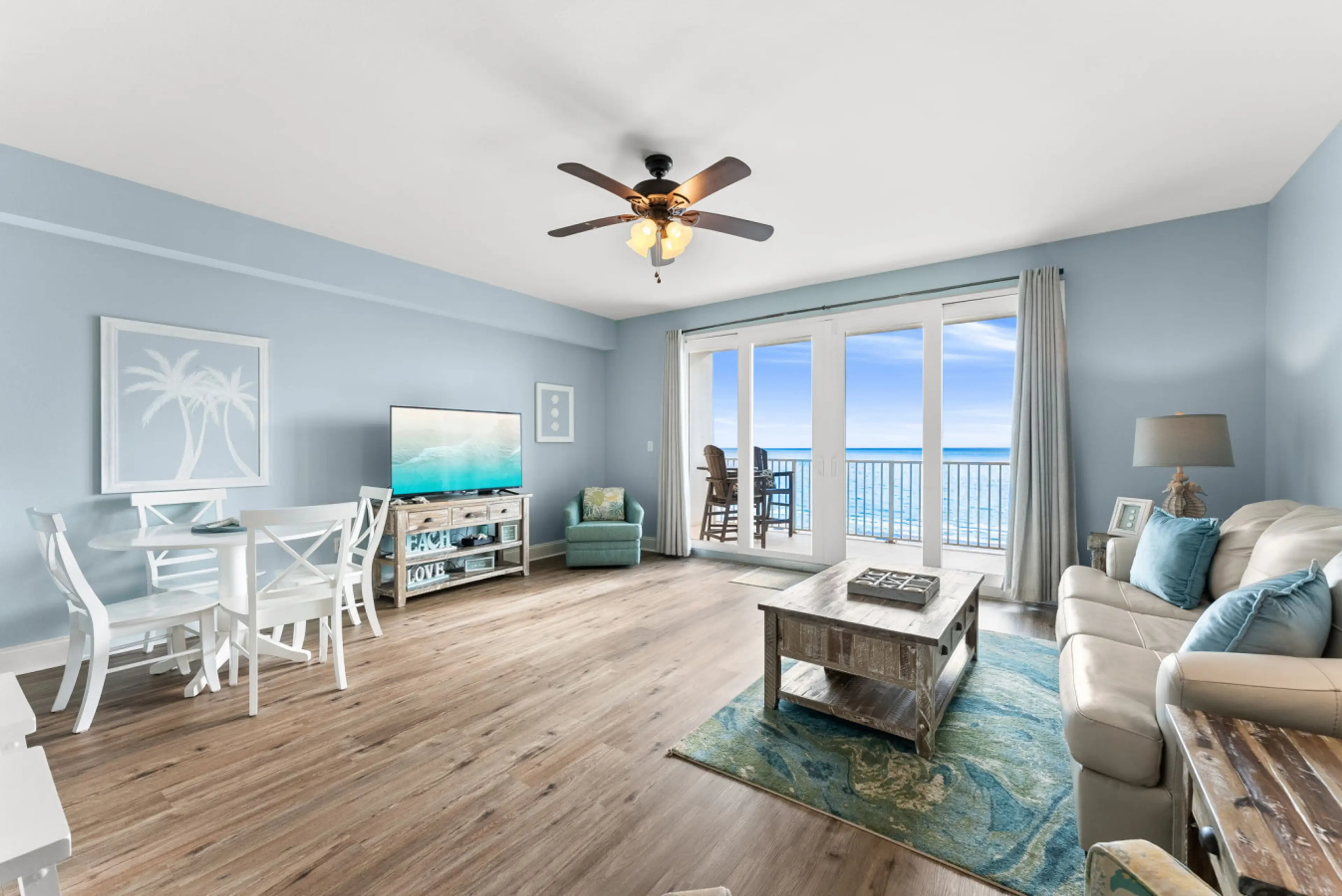 Open living and dining area with coastal décor and floor-to-ceiling Gulf views.