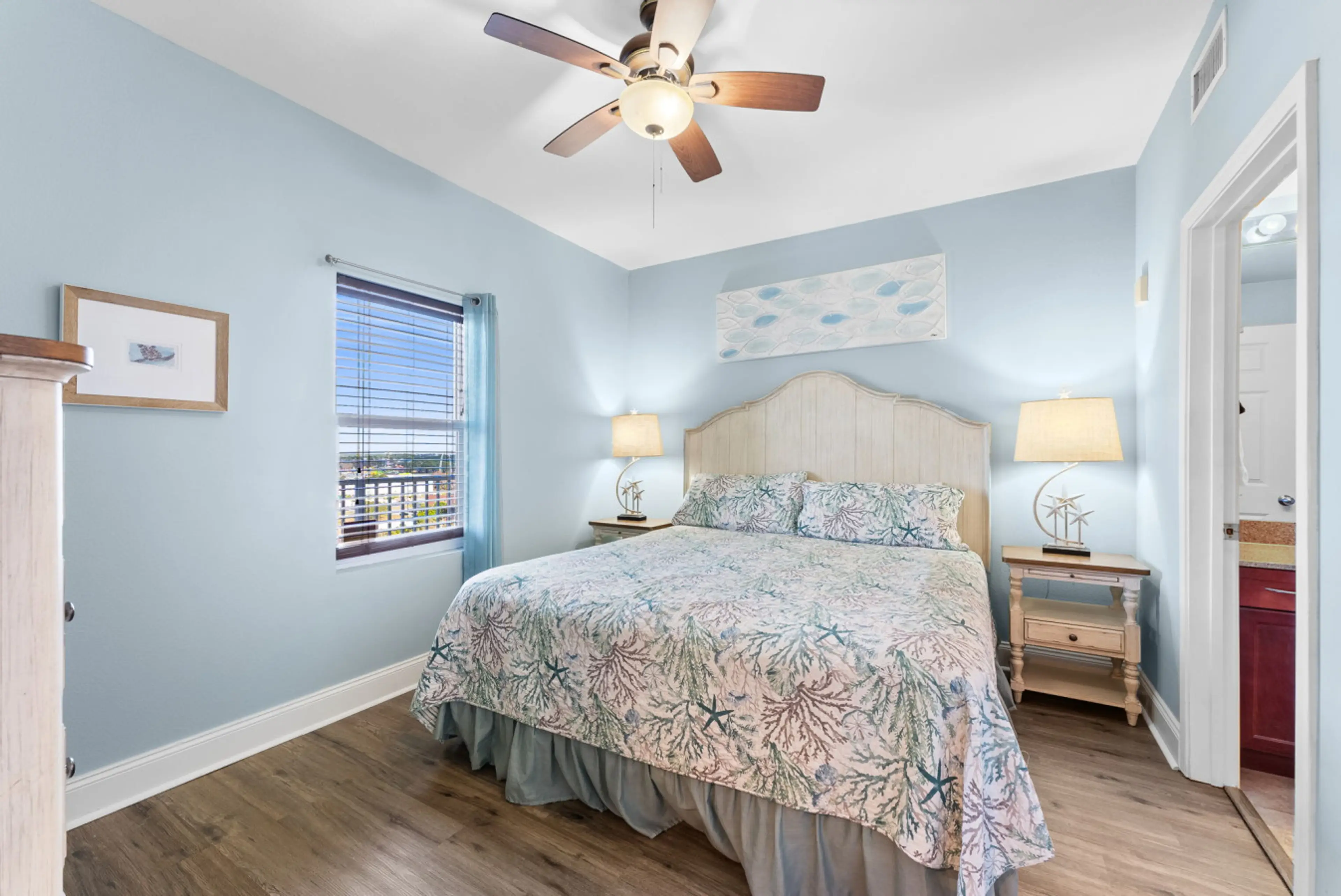Inviting master bedroom with a plush king bed, soft lighting, and serene coastal decor.