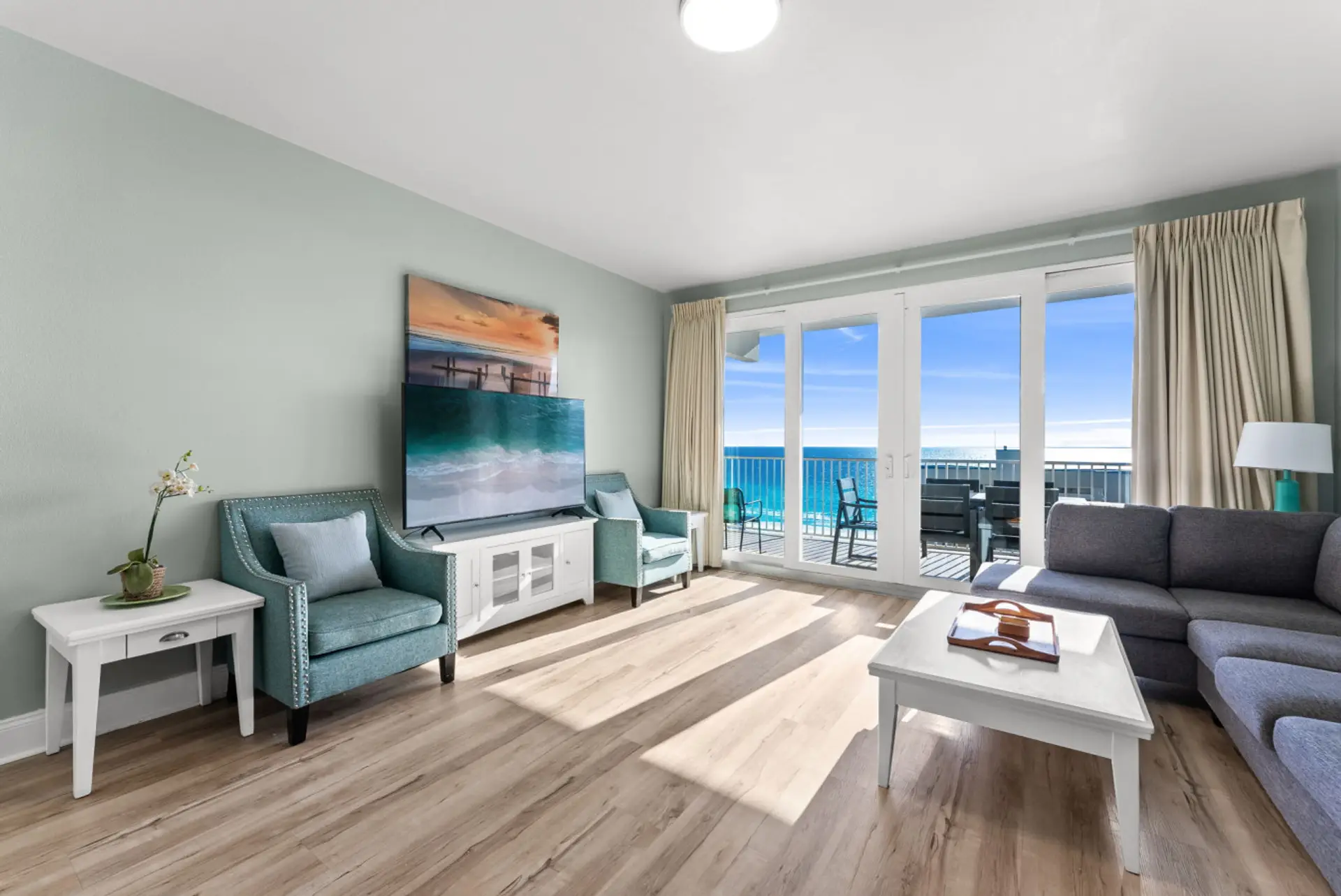 Coastal-themed living room with comfortable seating and direct access to the private Gulf-front balcony.