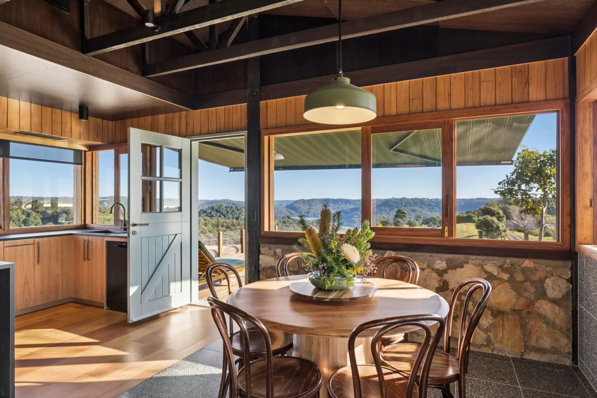 Open-plan kitchen, living and dining areas with wood fireplace and balcony access