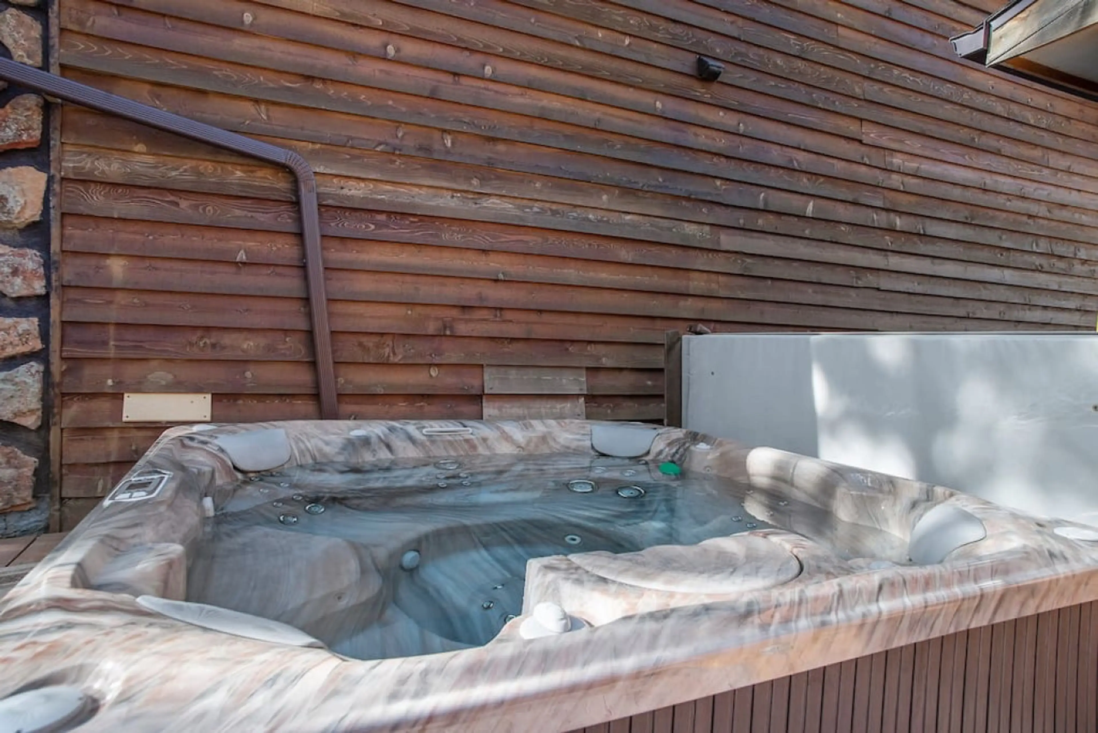 Step outside to enjoy the private hot tub, nestled in a serene outdoor setting