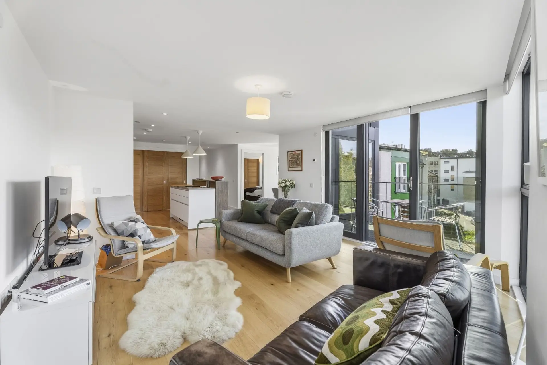 Comfortable open-plan living space with floor-to-ceiling windows and direct access to the private balcony.