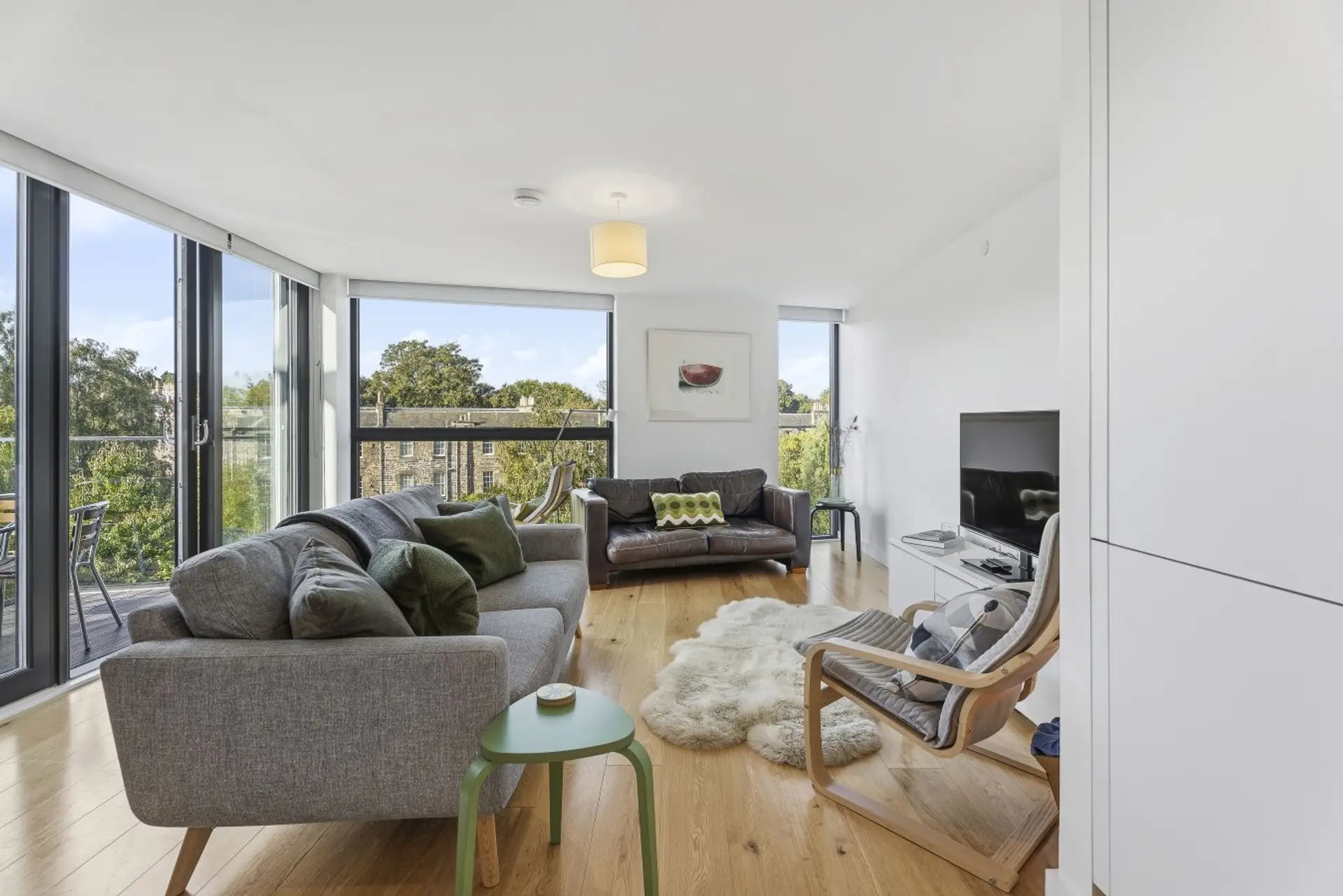 Spacious, light-filled living room with floor-to-ceiling windows and direct access to the private balcony.