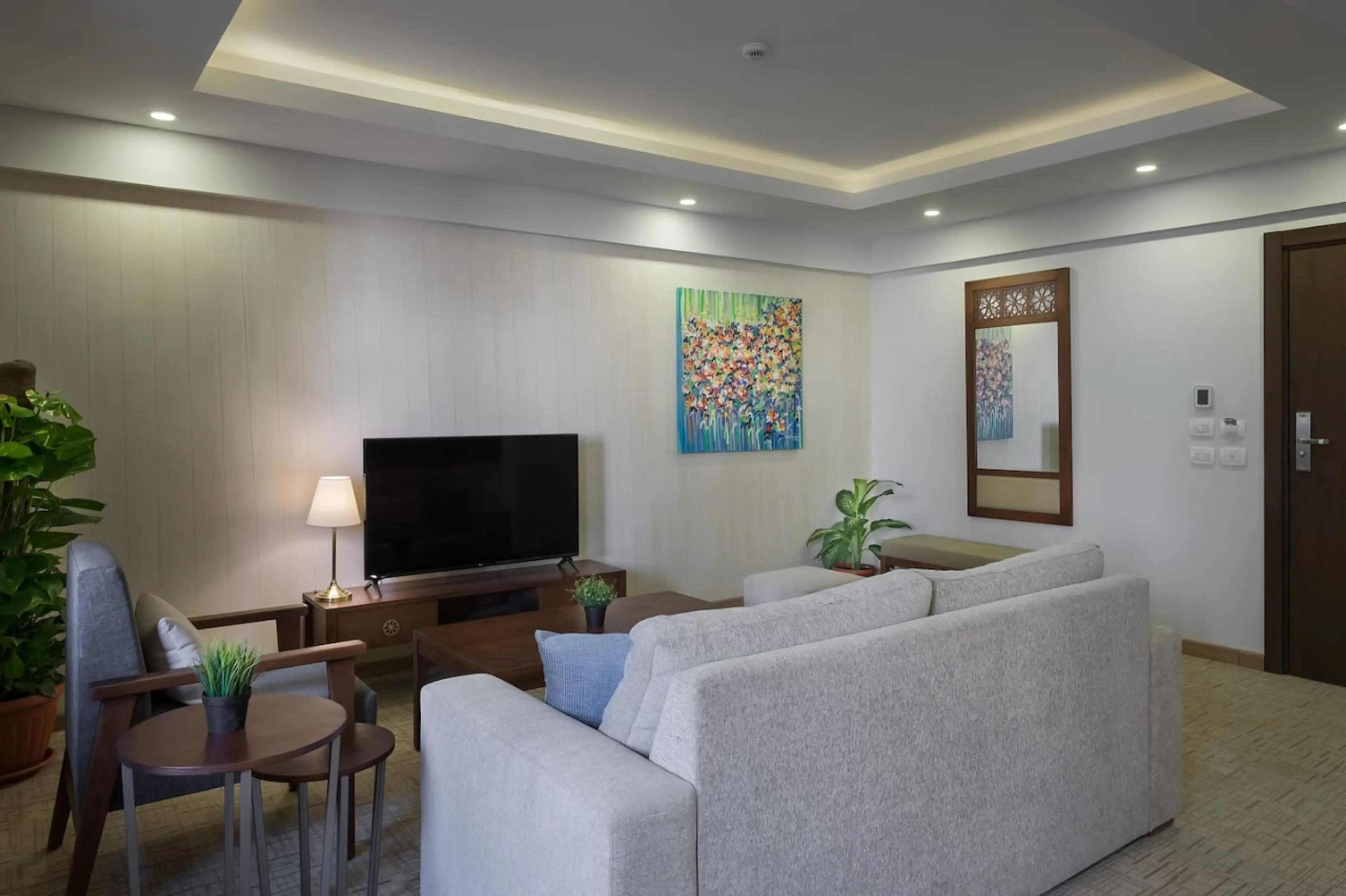 Your cozy corner! A comfy sofa bed, chairs, and a Smart TV—all bathed in natural light from the window.