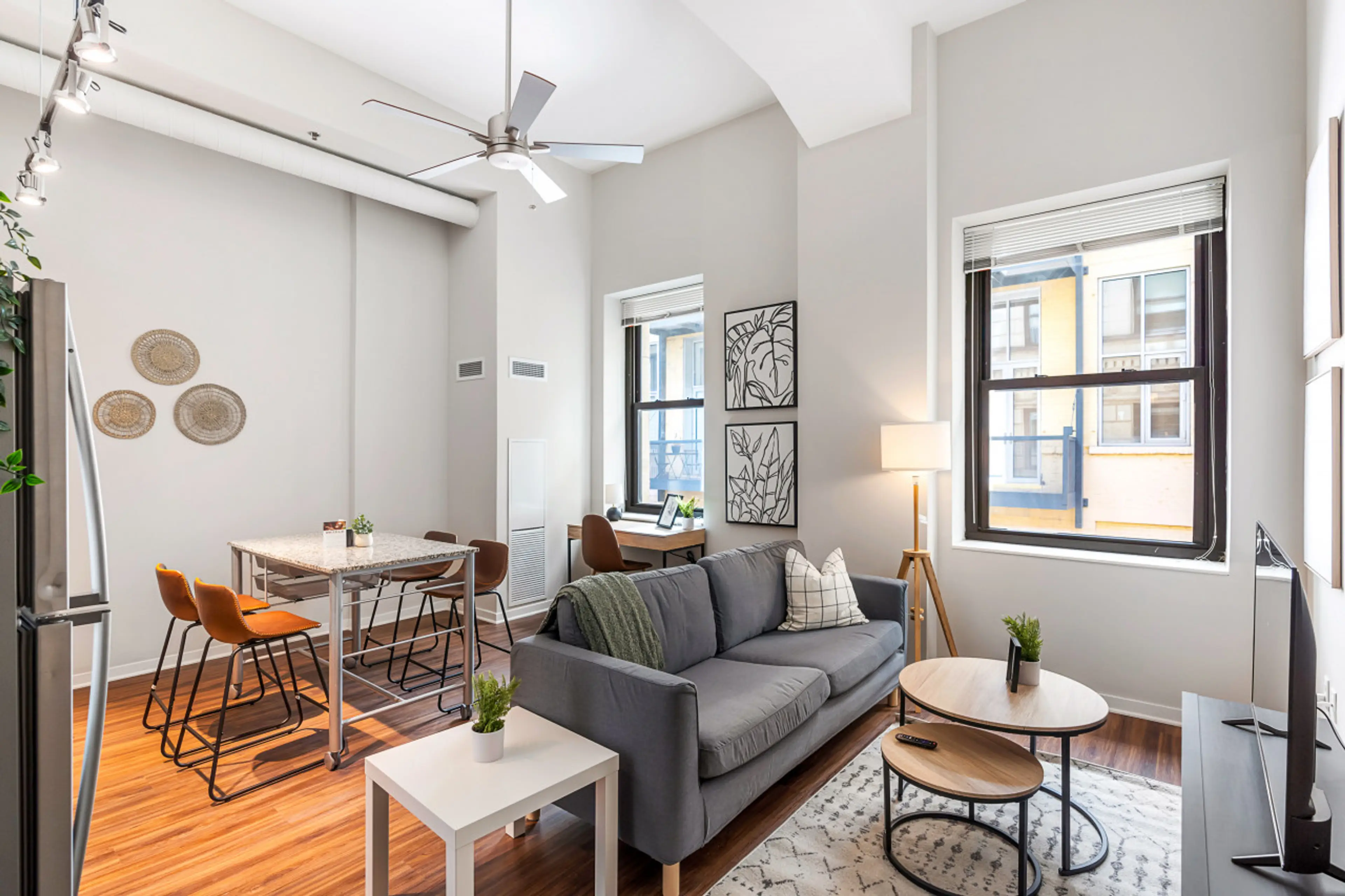 Spacious open-concept living and dining area featuring a vibrant sofa, modern furnishings, and a stylish entertainment setup—ideal for gatherings and relaxation.