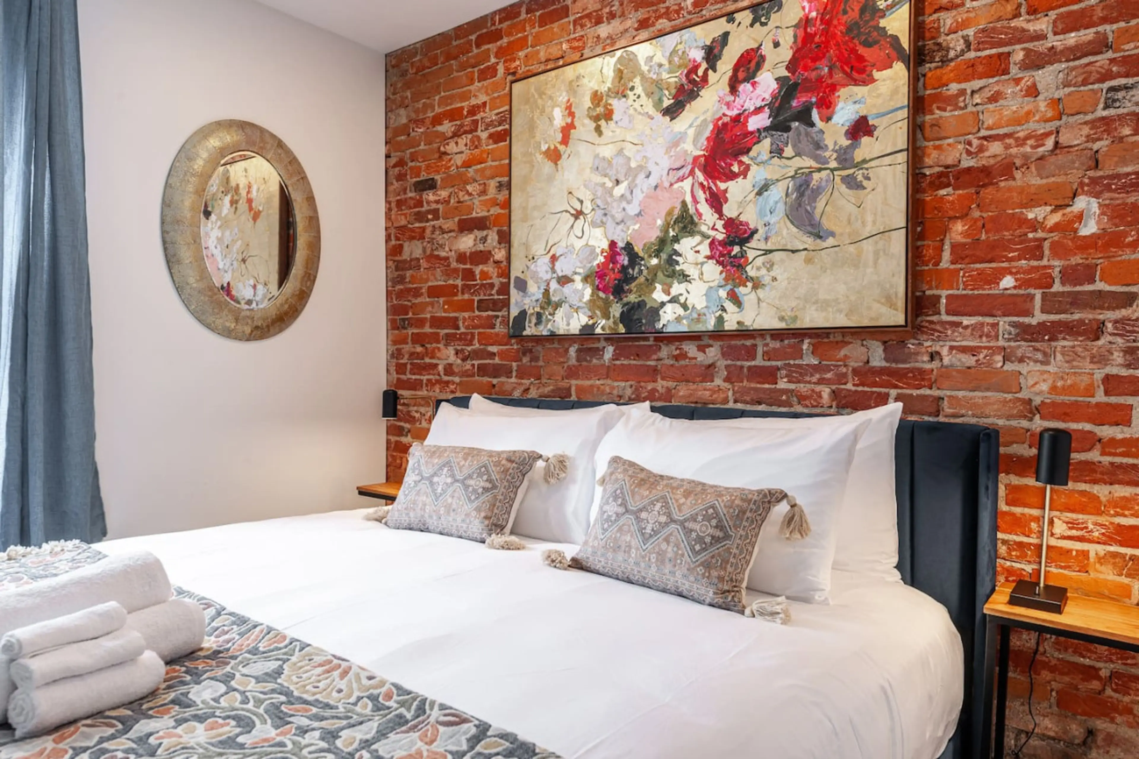 Cozy king bedroom in Unit 1 featuring a plush king-sized bed and small sitting area. Perfect for couples or solo travelers seeking a comfortable Stratford Festival accommodation, this bedroom offers relaxation after a full day of exploring the Stratford S