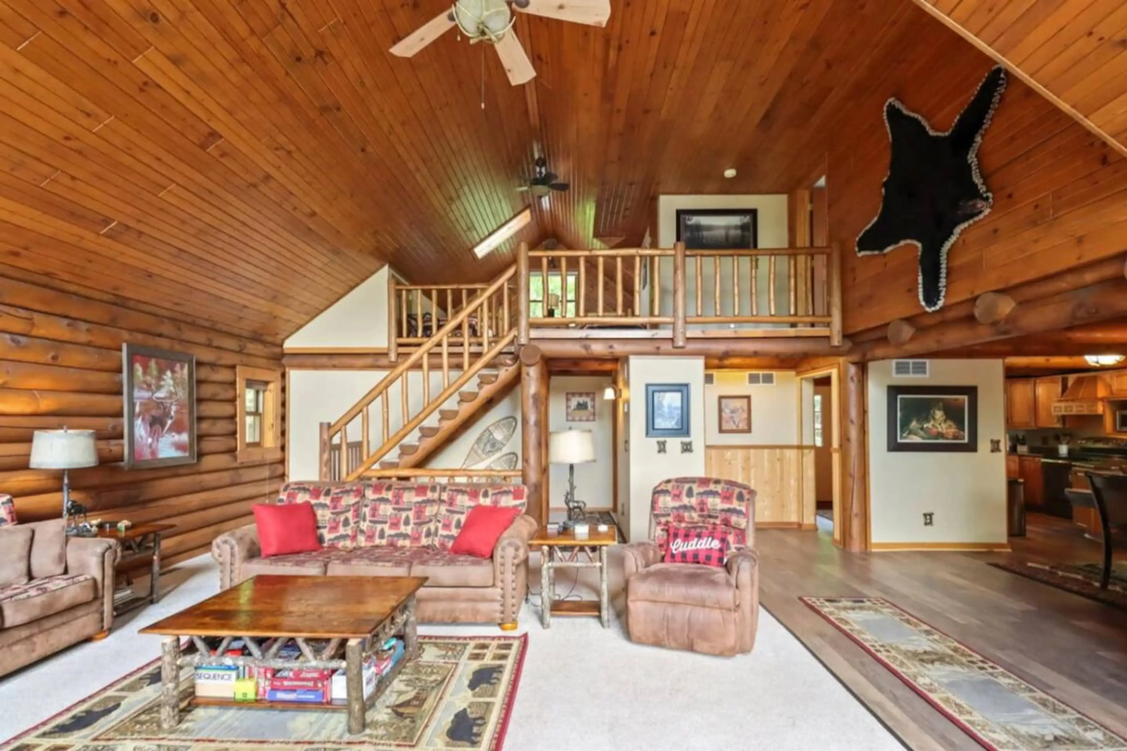 Unwind in our spacious log-style living room featuring vaulted pine ceilings, rustic furniture, and a comfy recliner with a “Cuddle” pillow calling your name. Perfect for game nights, fireside chats, or curling up after a day on Little St. Germain Lake!