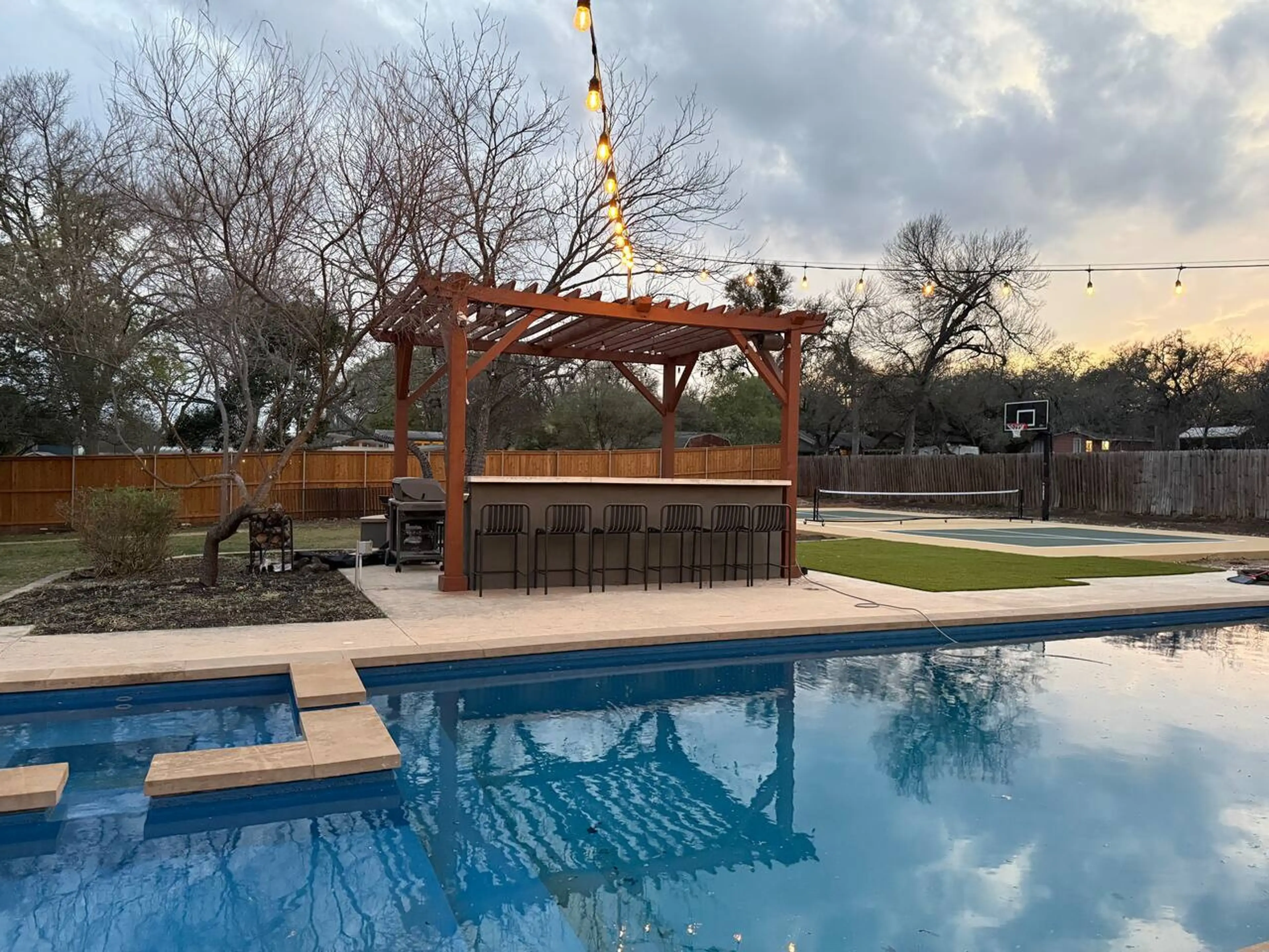 Private Austin resort-style compound with heated pool, sport court, and multiple outdoor gathering spaces designed for large group stays.