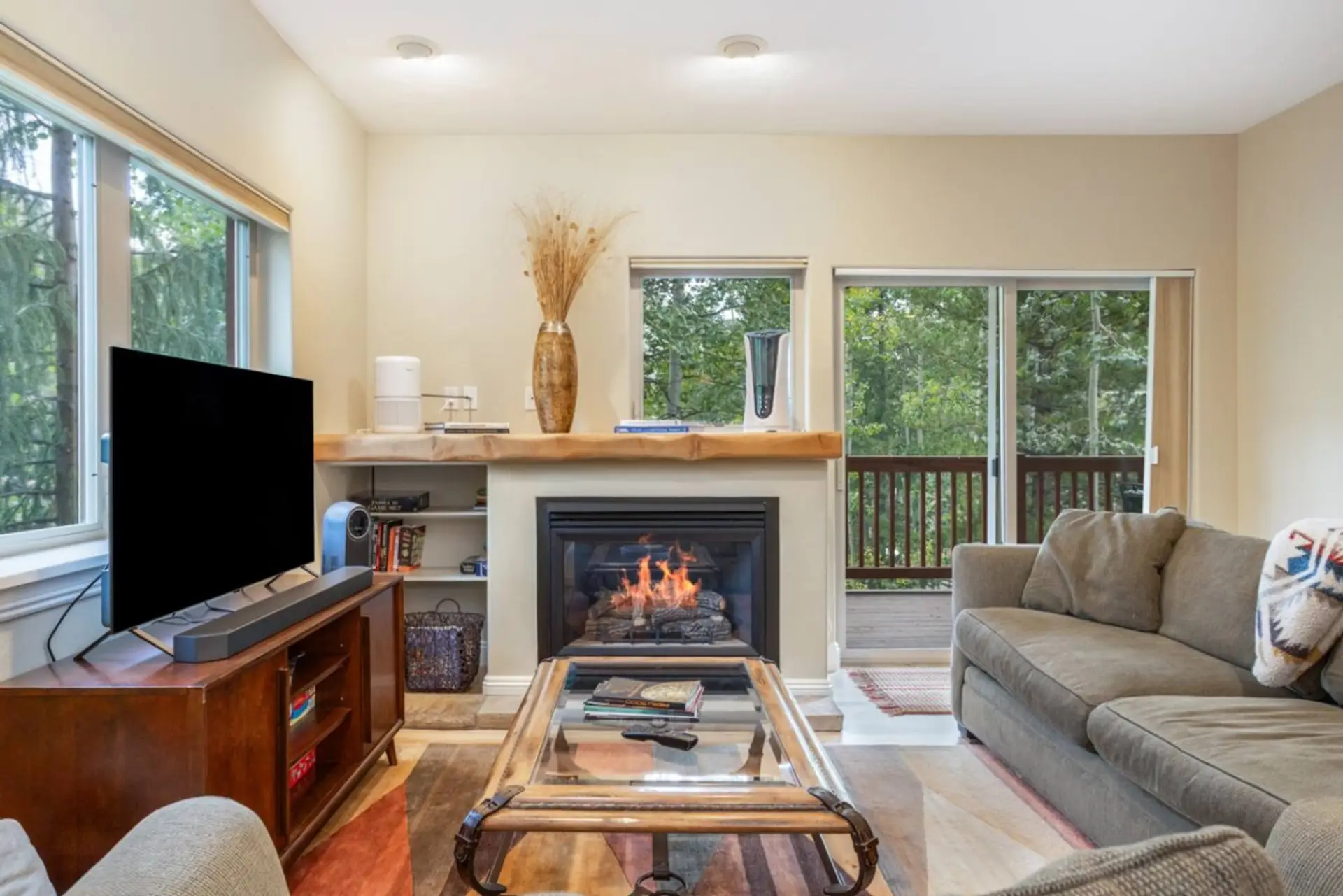 Cozy family living room with a fireplace and beautiful creek views—perfect for relaxing after a day of Vail adventures