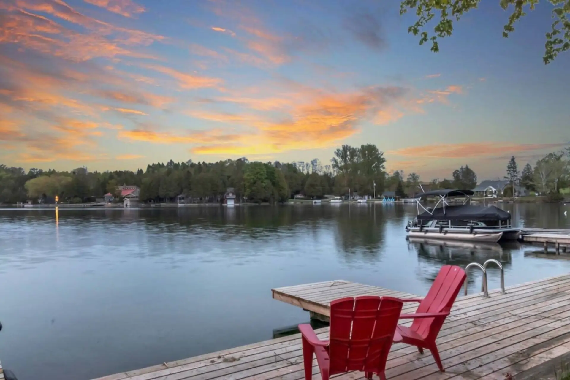 Watch the sun dip below the horizon as the lake reflects shades of gold and rose. Settle into the red chairs, breathe in the fresh air, and listen to the gentle lapping of water against the dock. This is a place where mornings invite you to linger over co