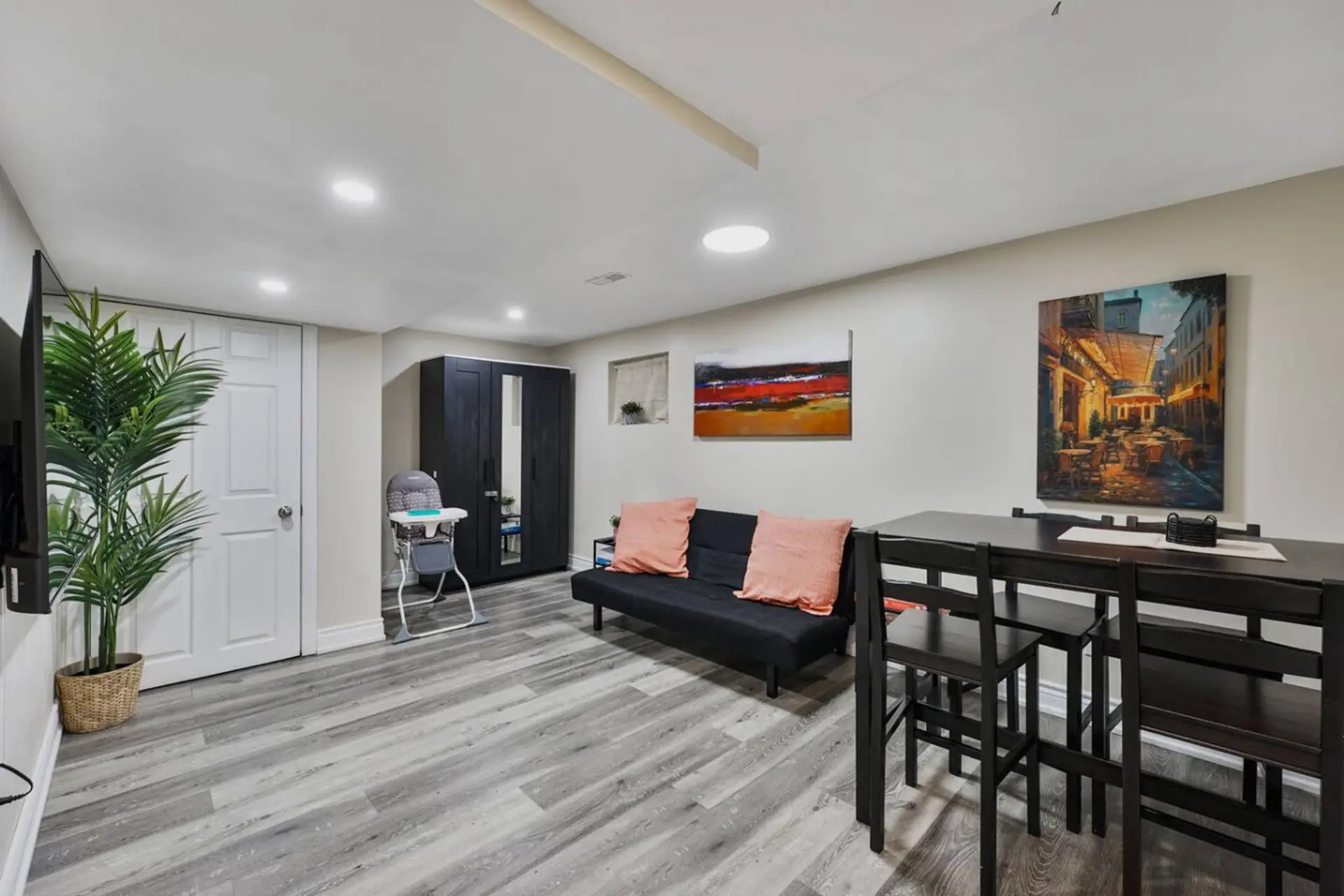 Welcome to a spacious retreat designed for relaxation and enjoyment. This versatile area features a comfortable futon, a dining table for shared meals, and vibrant artwork, creating an inviting atmosphere for your stay.