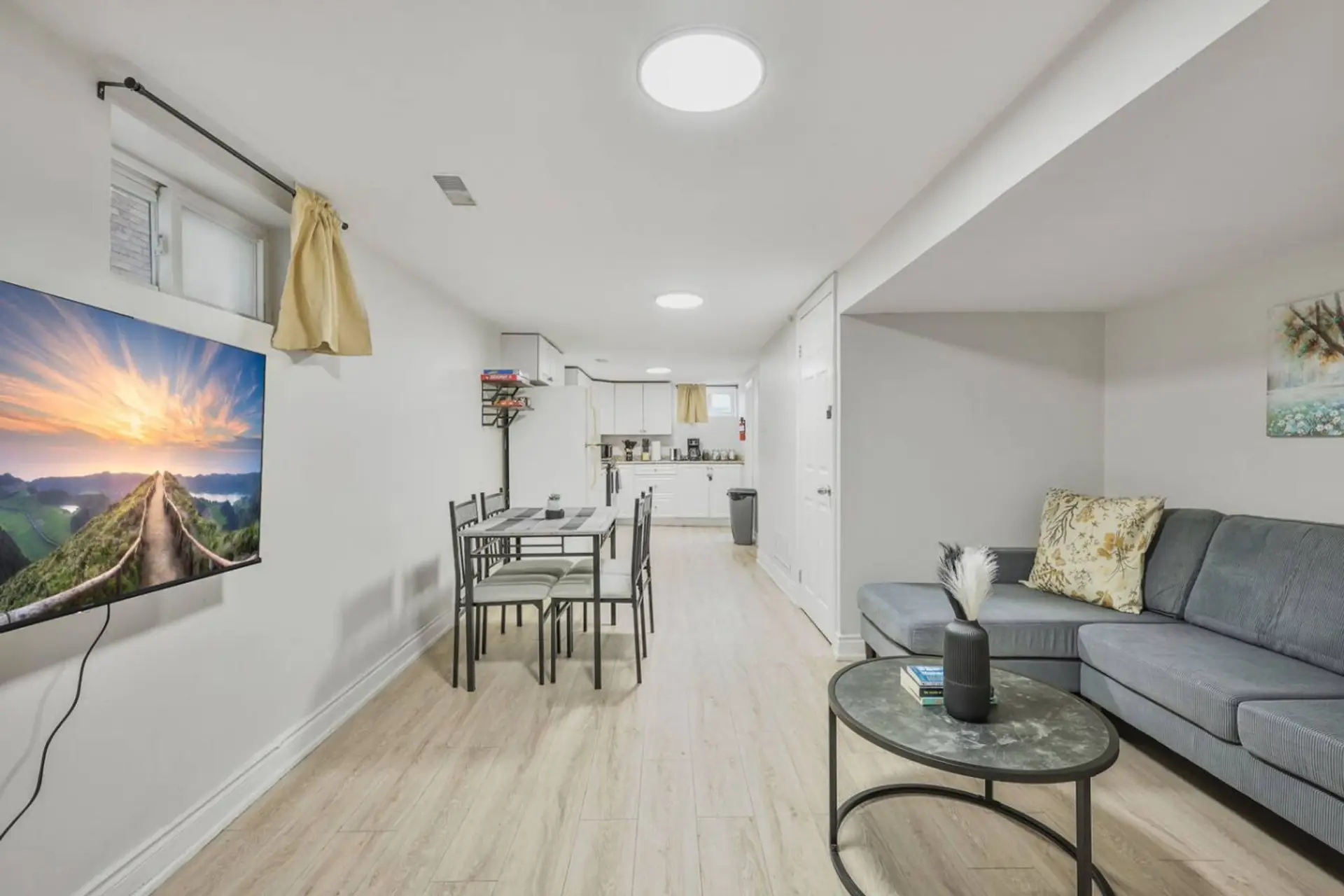Enjoy a bright open living space with a cozy sectional, dining area, and fully equipped kitchen. Perfect for gathering, relaxing, or sharing meals, this inviting setup makes every stay feel like home.